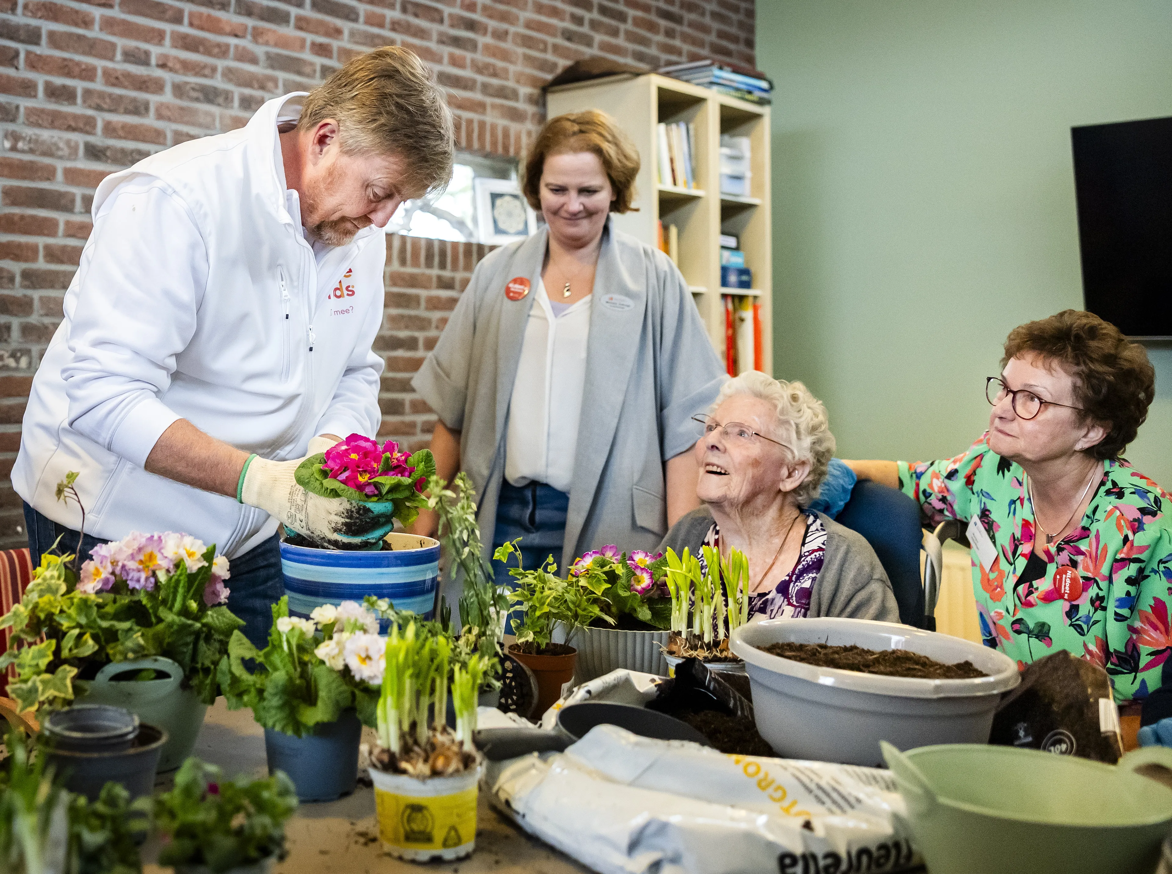 Koning Willem-Alexander in gesprek met een van de ouderen die op de woonzorglocatie wonen.