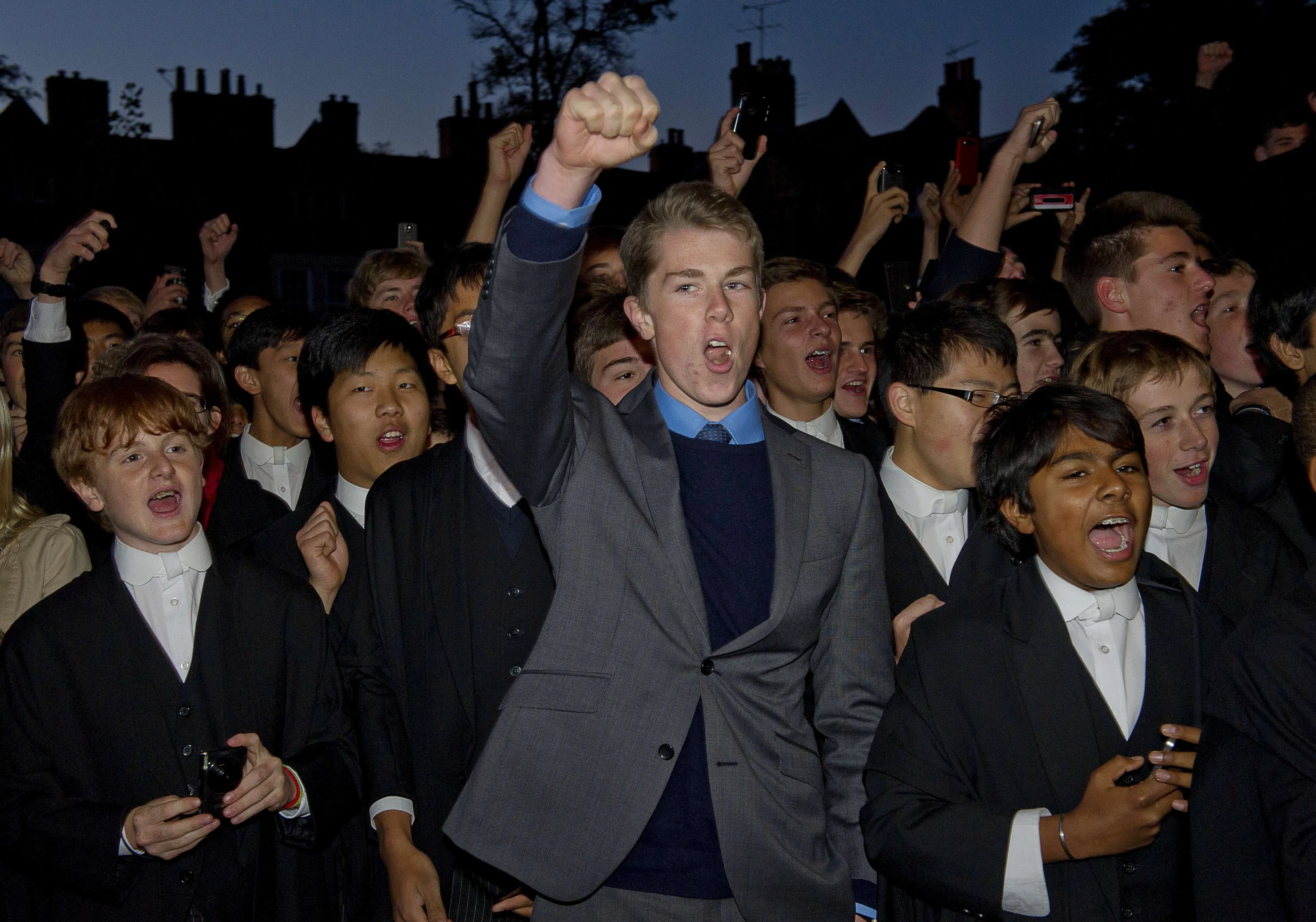 Leerlingen van Eton College wachten koningin Elizabeth tijdens een van haar bezoeken aan de school.