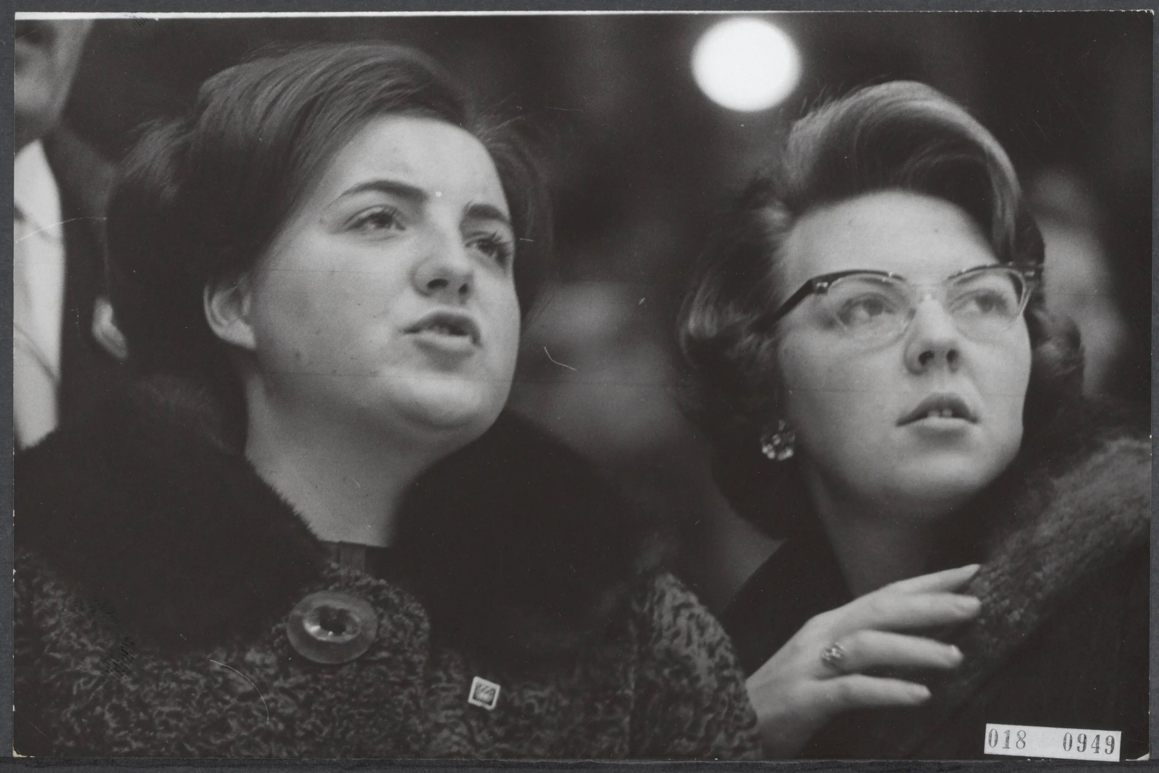 Prinsessen Margriet en Beatrix kijken vol spanning toe naar een wedstrijd ijshockey (1964).