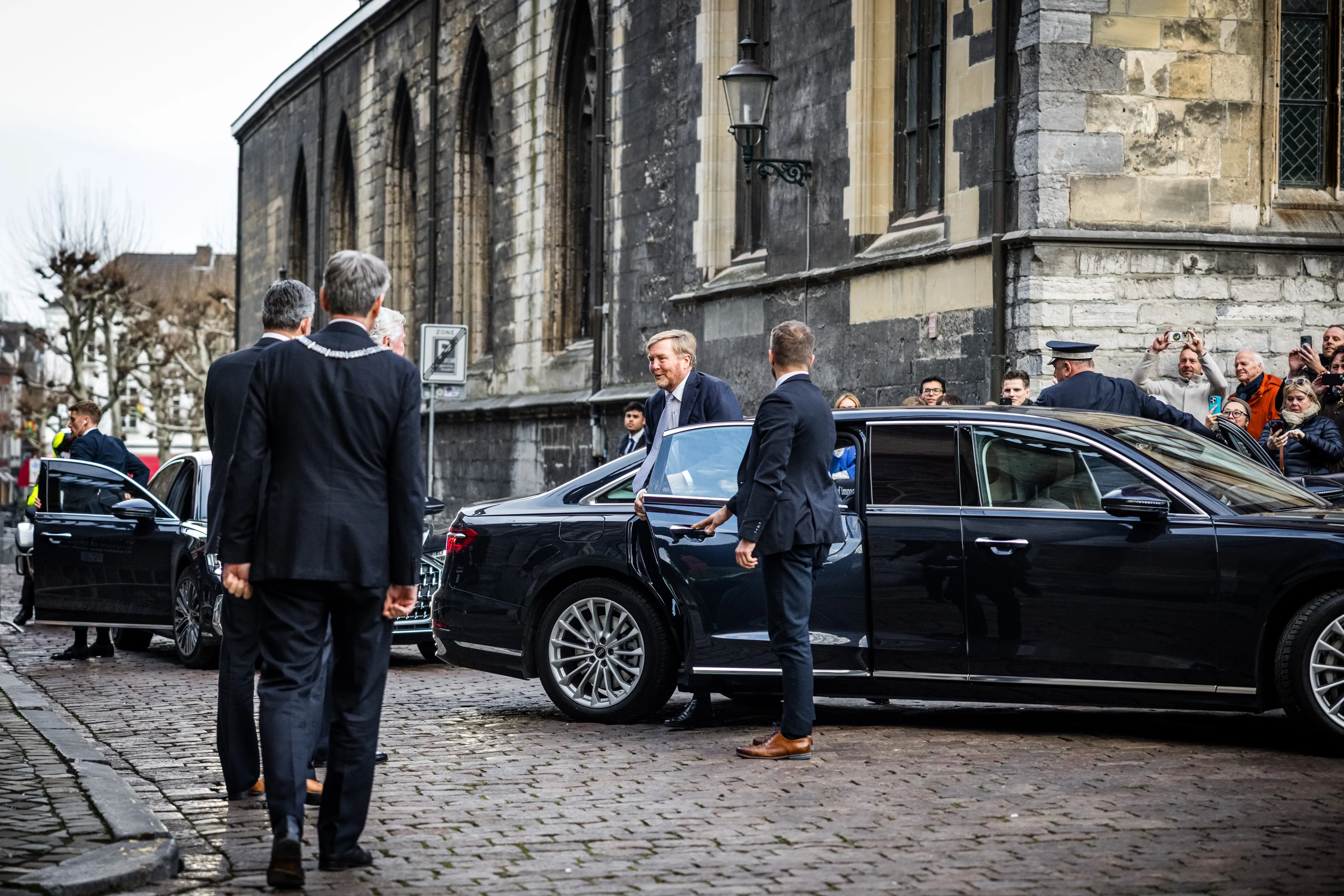 De koning stapt uit zijn auto tijdens een bezoek aan Maastricht.