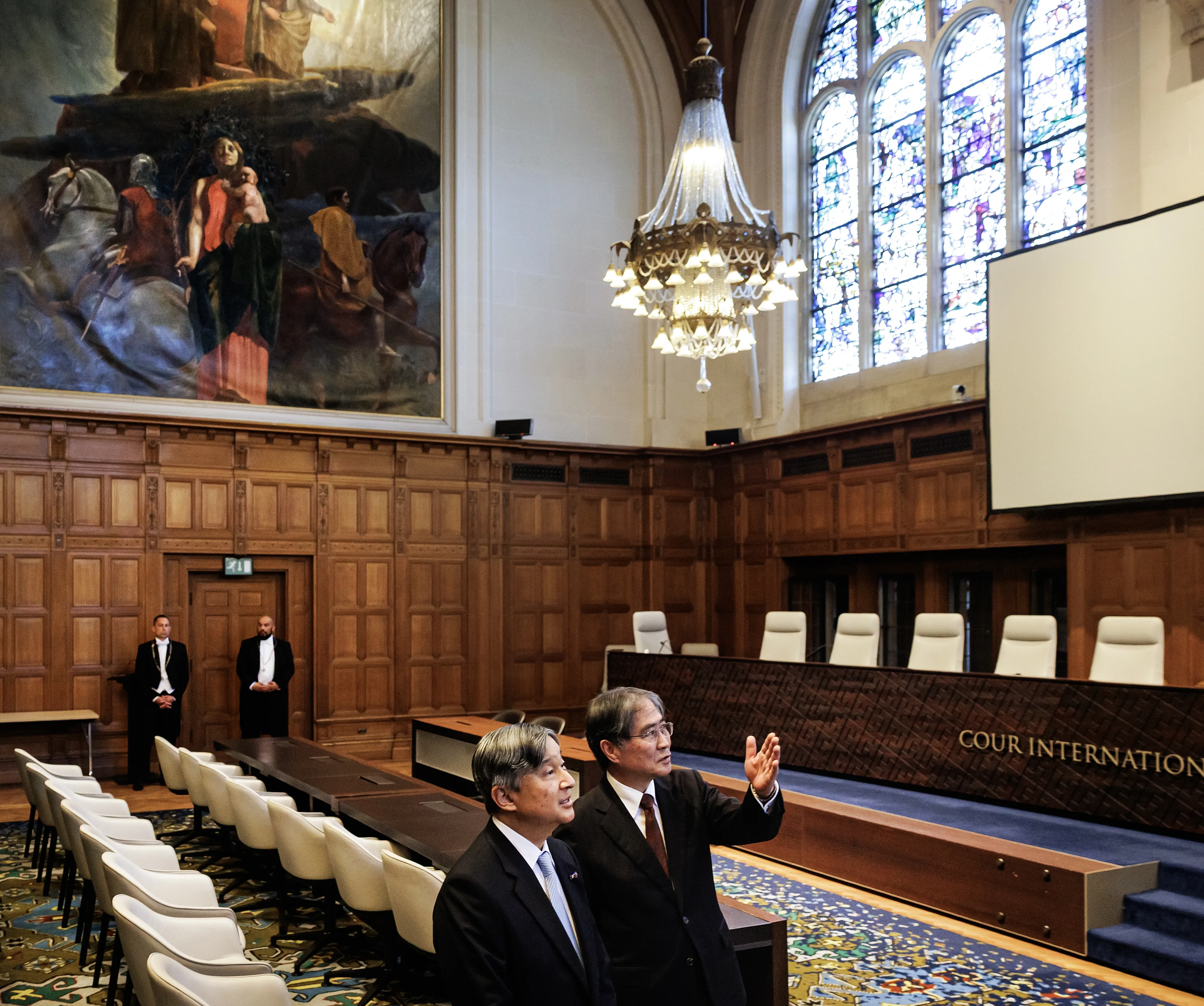 De keizer krijgt een rondleiding door de secretaris-generaal van het permanent hof van arbitrage, Marcin Czepelak, en de president van het Internationaal Gerechtshof, Iwasawa Yuji.