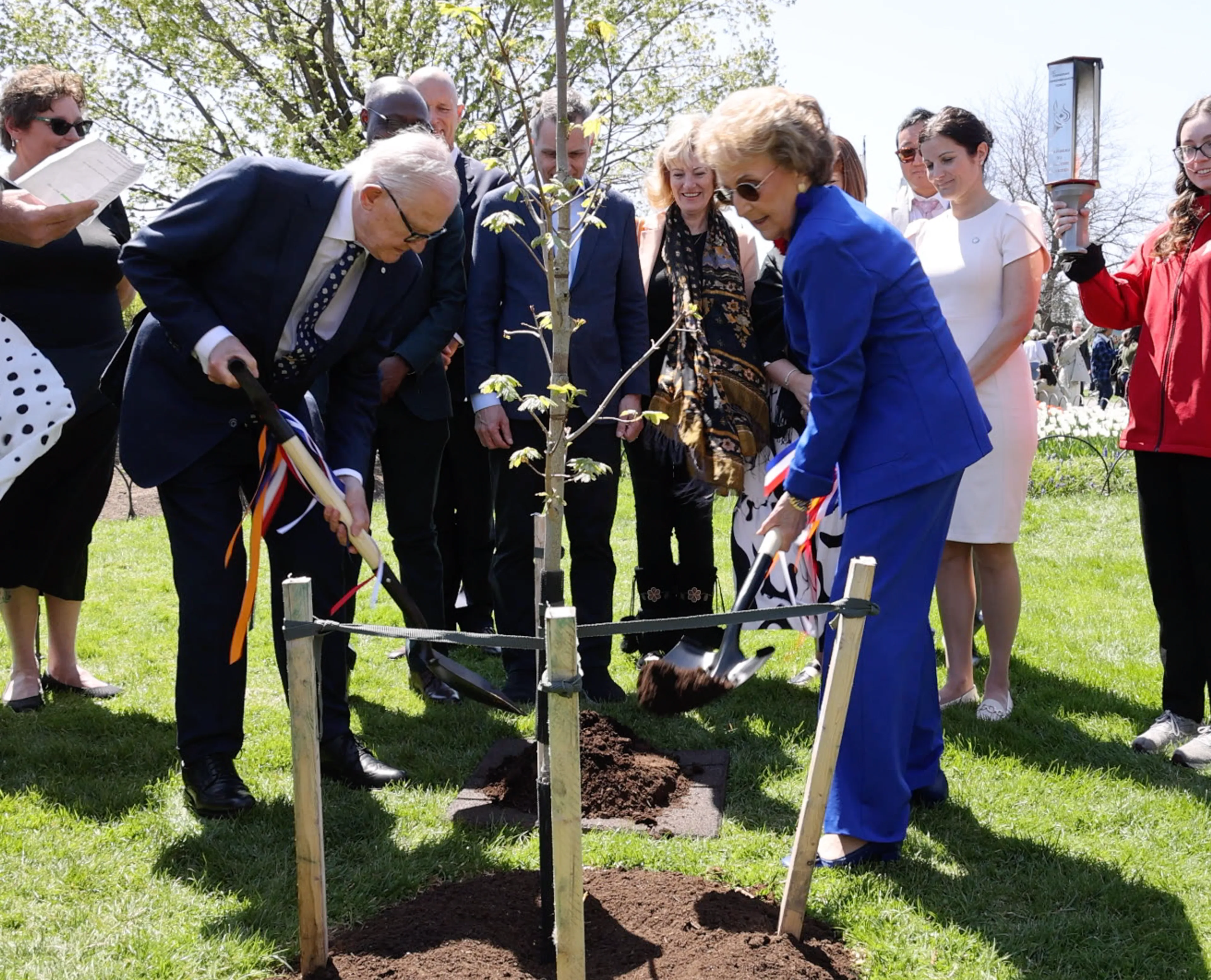 Prinses Margriet en Pieter van Vollenhoven scheppen aarde bij de boom.