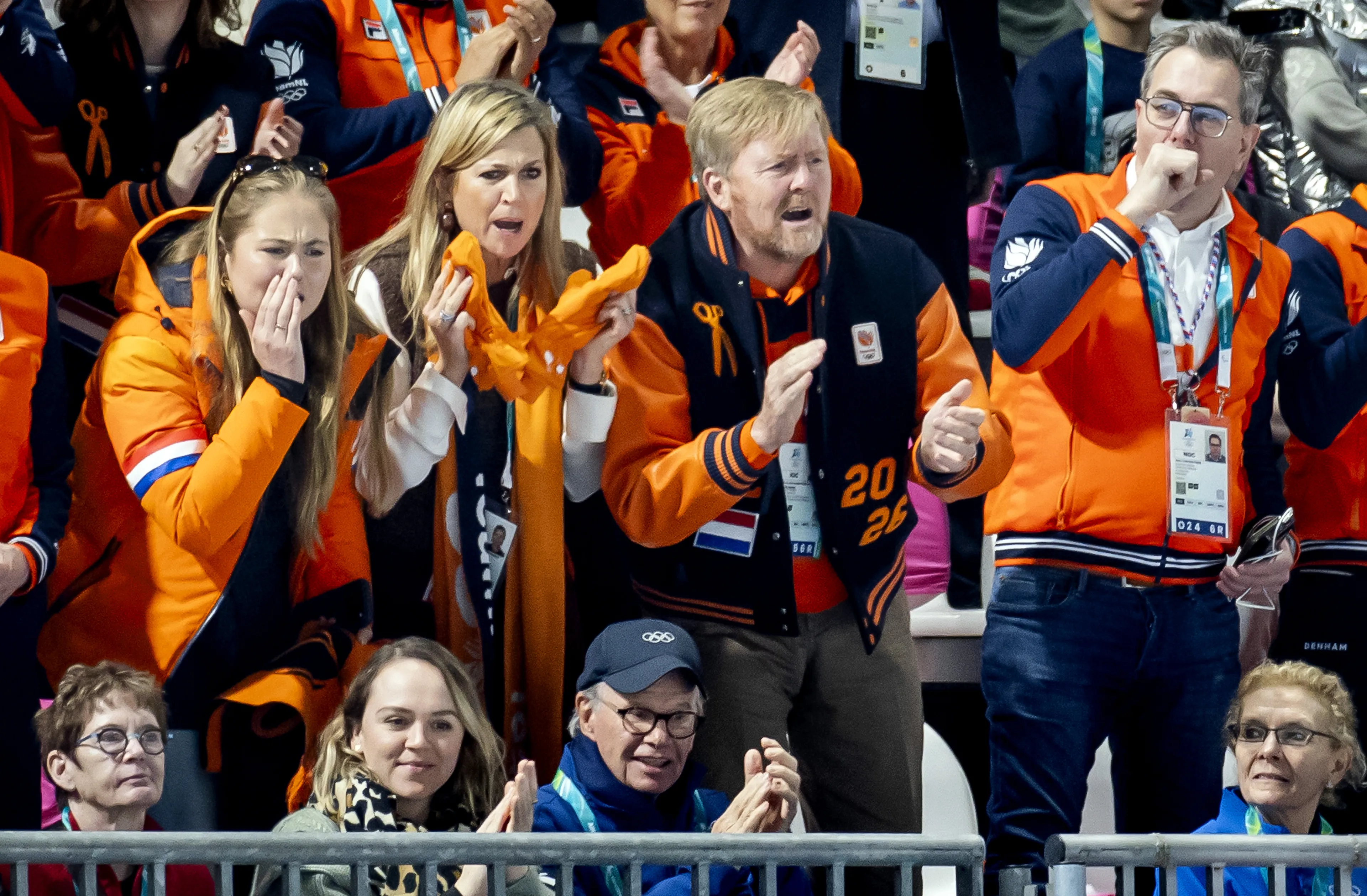 Het drietal juicht de Nederlandse schaatsers toe vanaf de tribune.