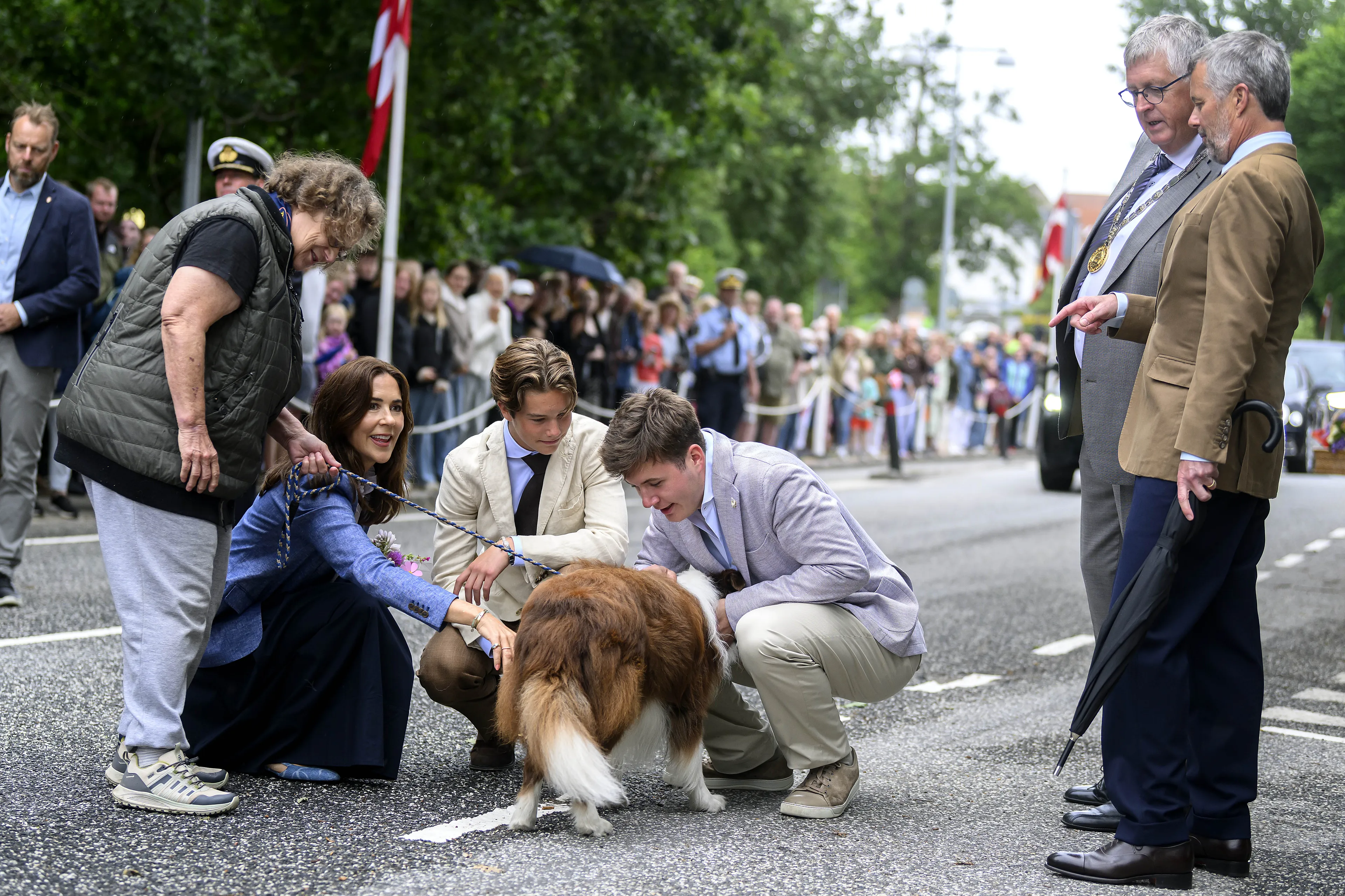 Een hond krijgt uitgebreid aandacht van de royals.