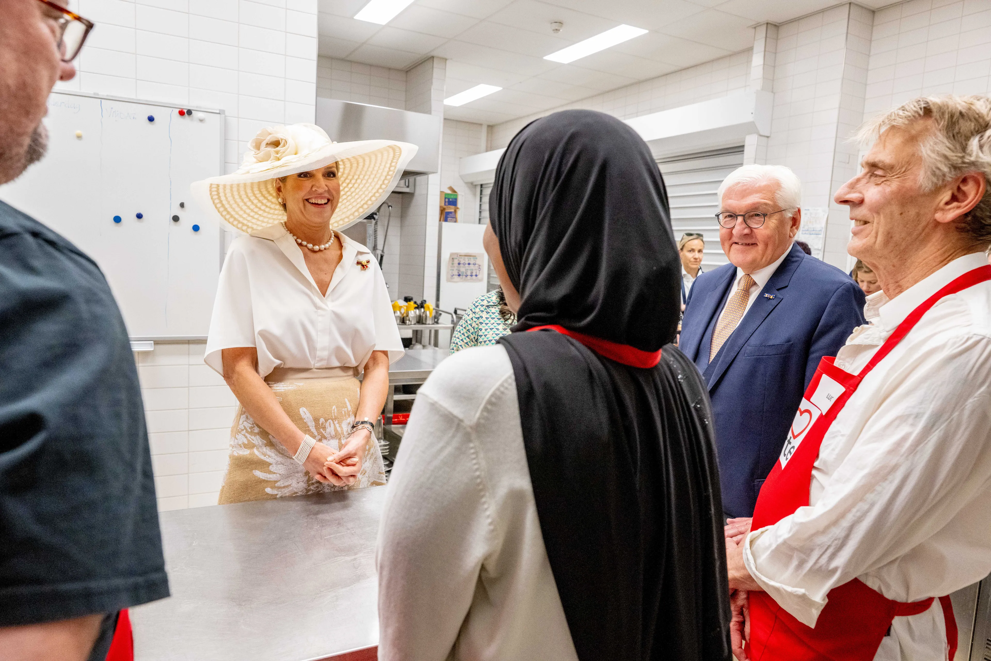 Koningin Máxima en bondspresident Steinmeier luisteren naar medewerkers van Resto VanHarte.