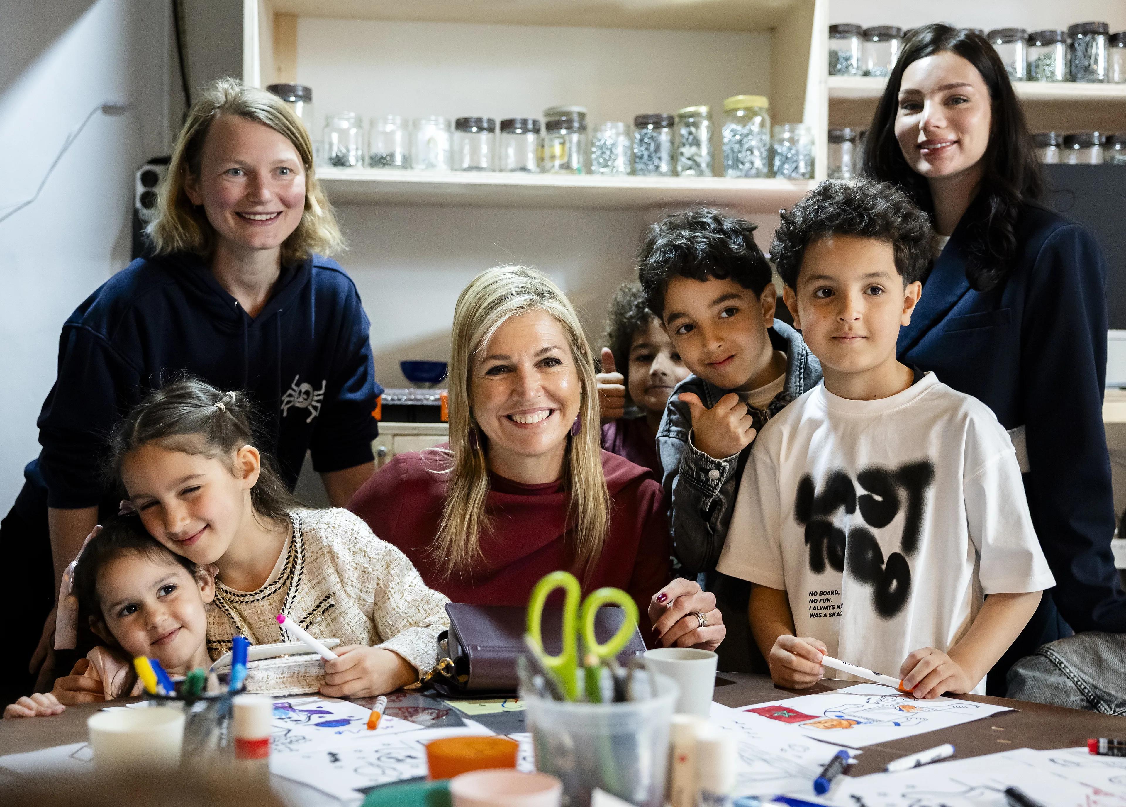 Koningin Máxima met de kinderen en vrijwilligers van het buurthuis.
