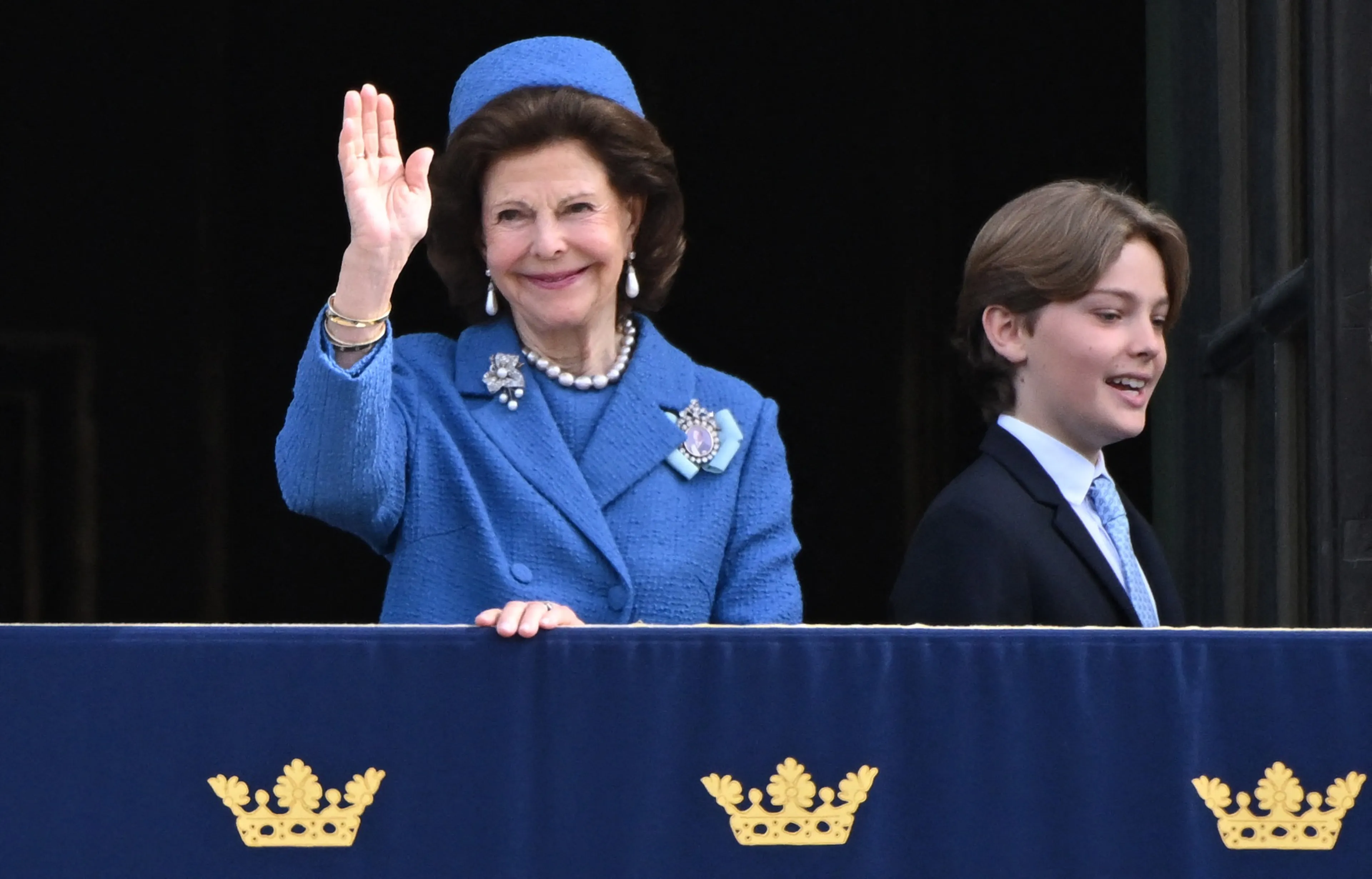 Koningin Silvia kijkt toe vanaf het balkon.