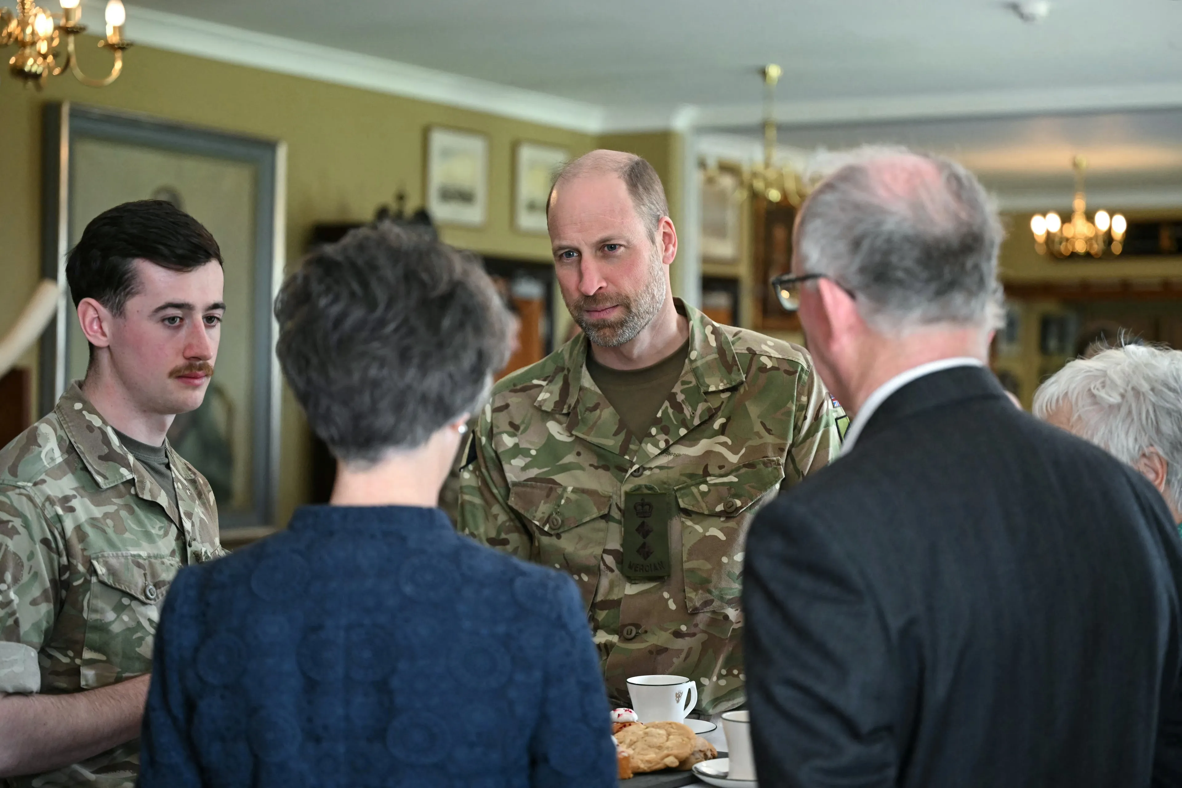 De prins van Wales in gesprek met familieleden van de militairen van het regiment.