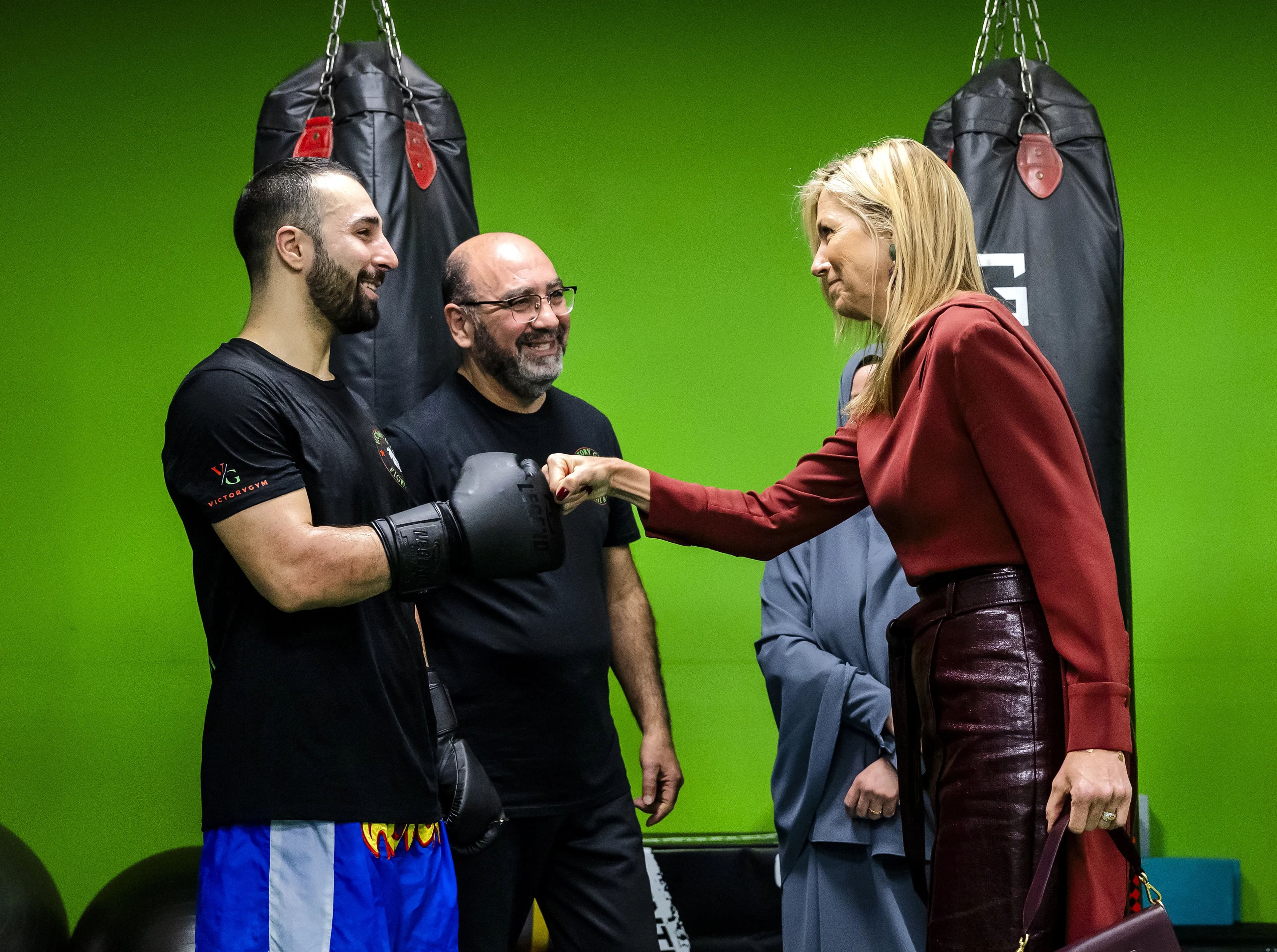 De koningin geeft een boks aan een sporter.