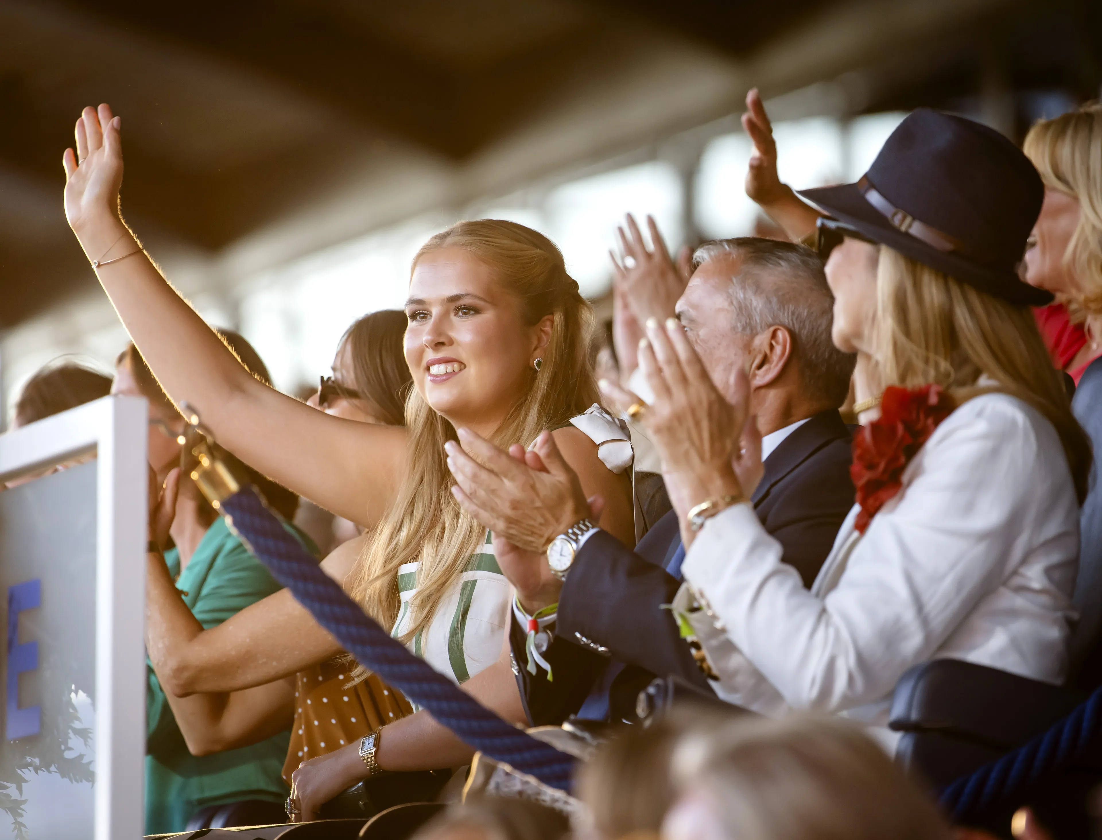 Amalia zwaaiend op de tribune.
