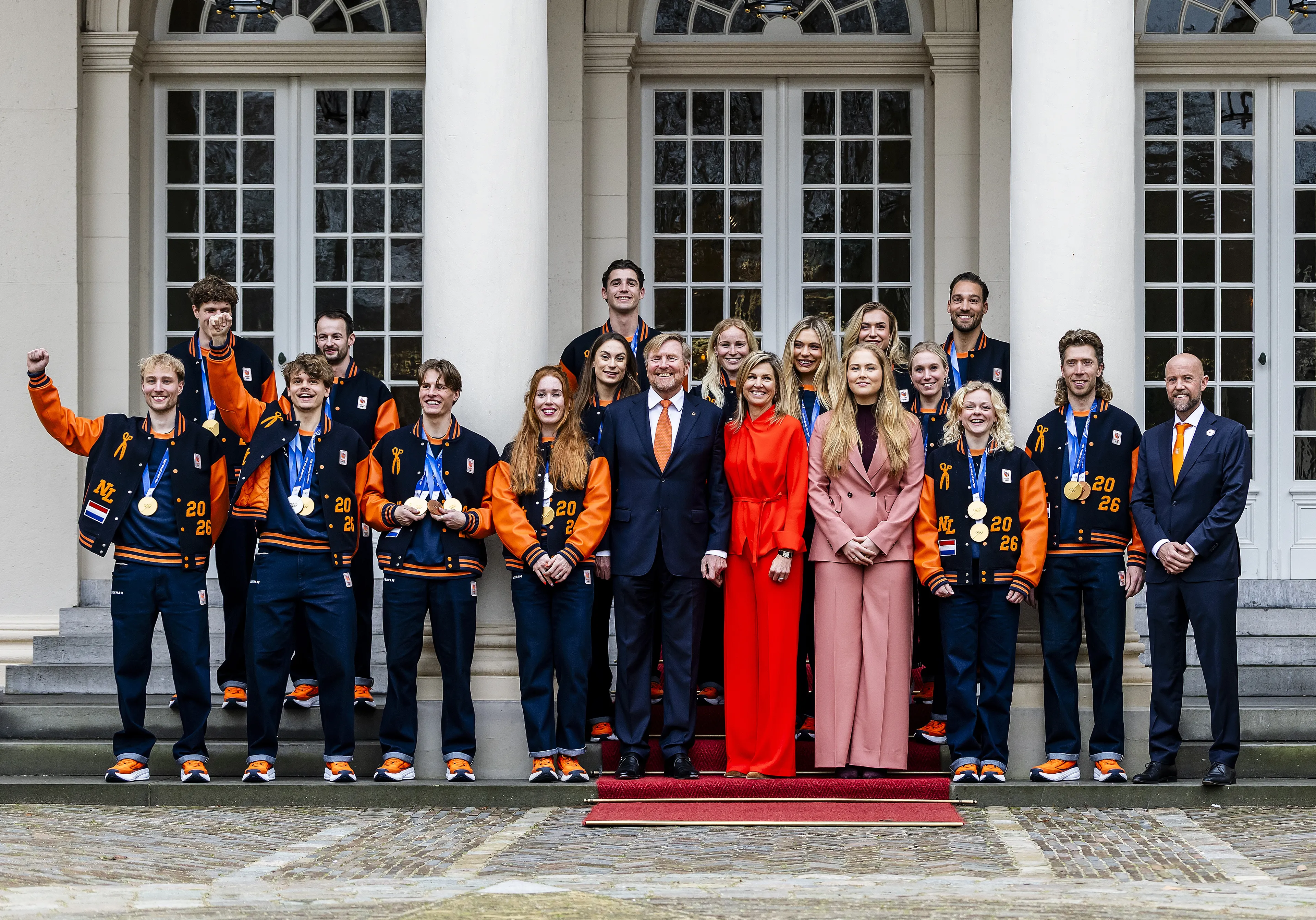 Koning Willem-Alexander, koningin Máxima en prinses Amalia poseren met de medaillewinnaars.