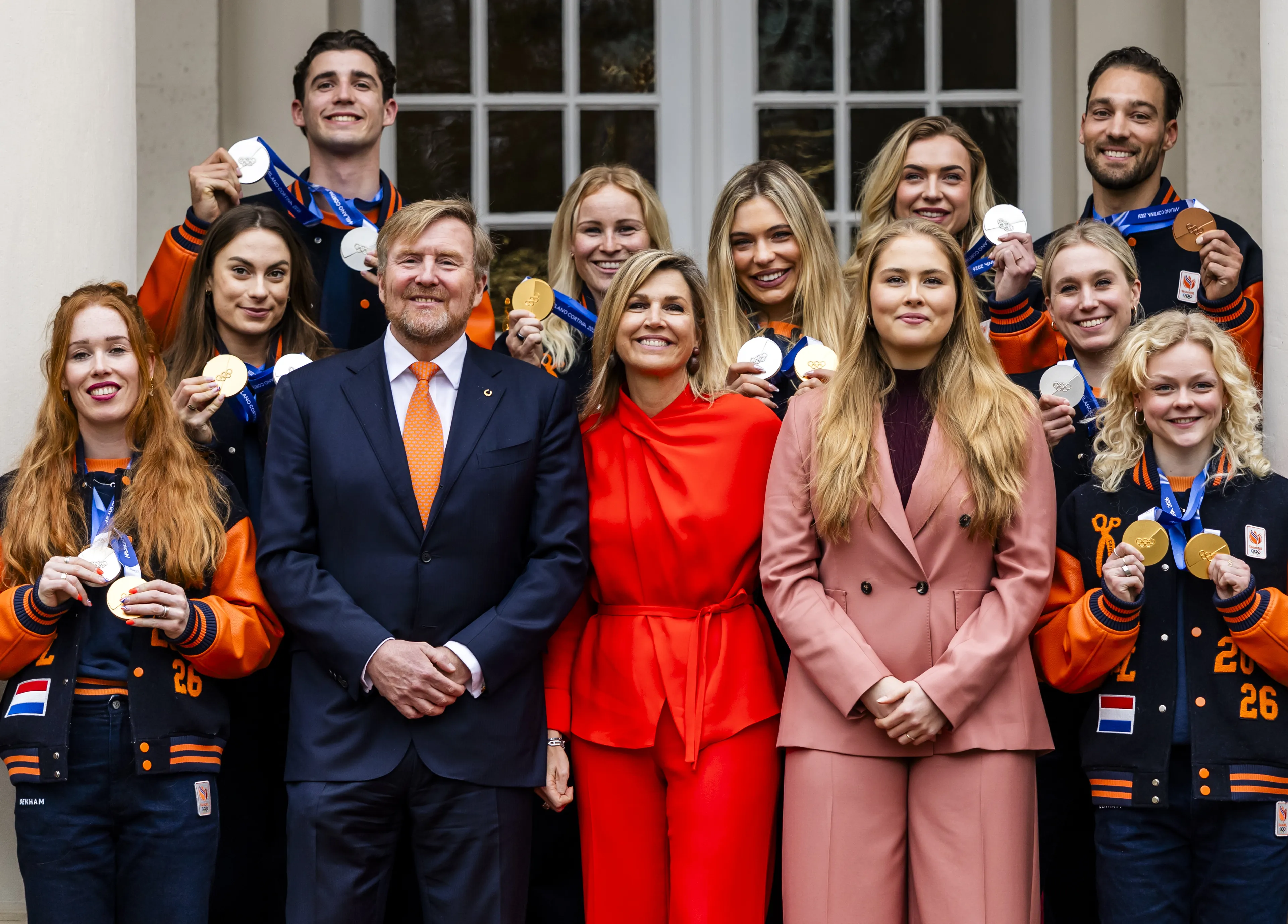 Het koningspaar en prinses Amalia met de medaillewinnaars.