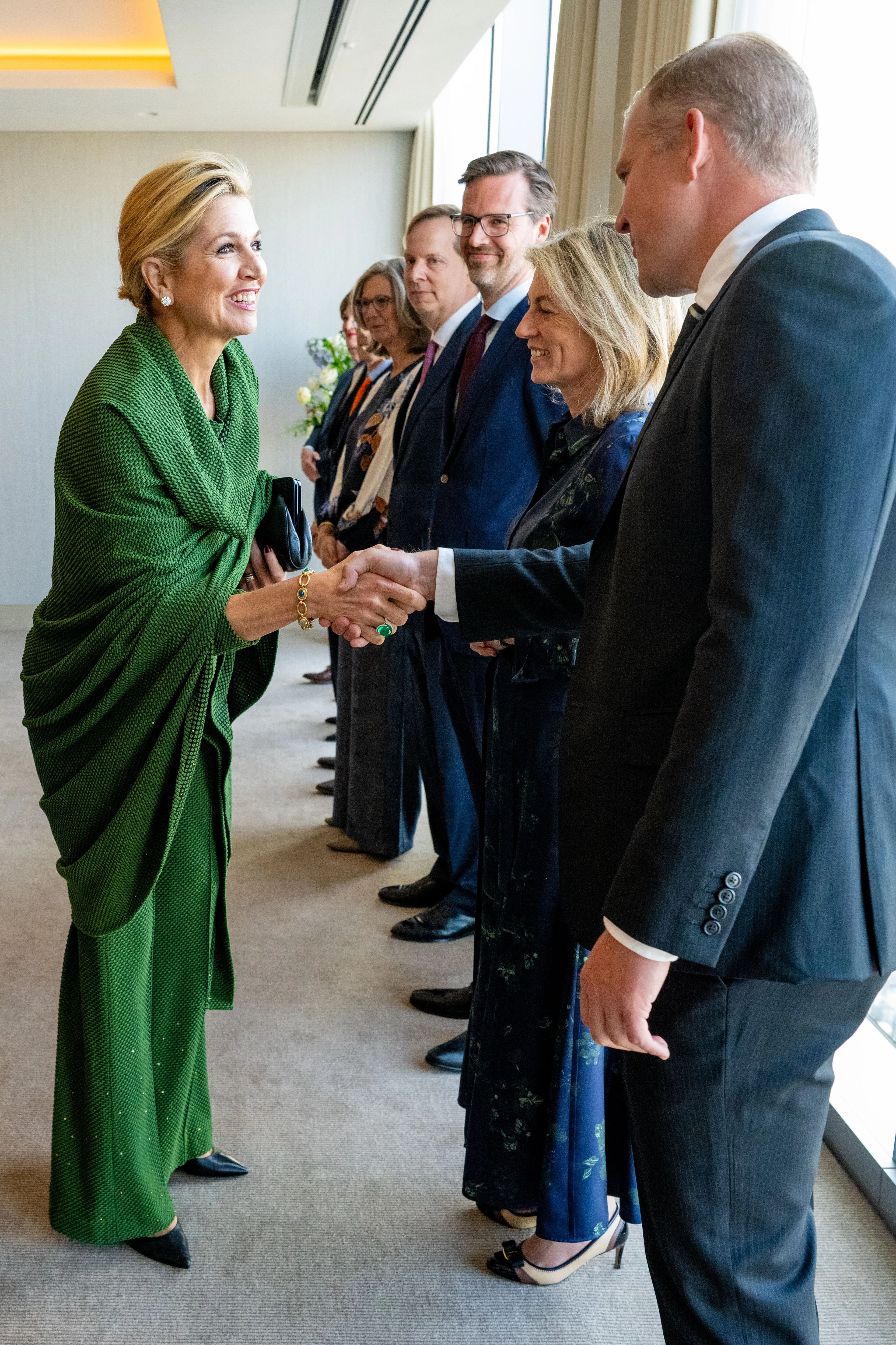 Koningin Máxima droeg een groene omslagdoek over de outfit heen.