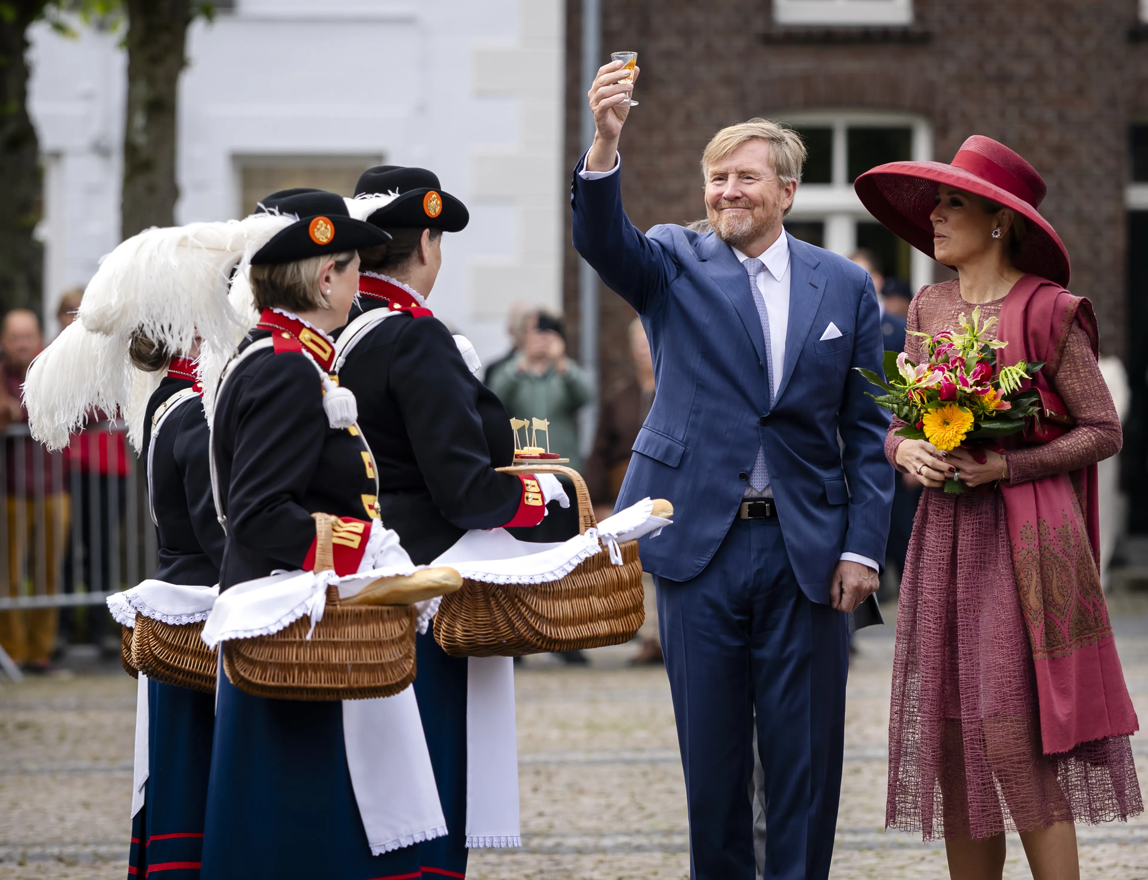 Het koningspaar krijgt een lokaal hapje en drankje aangeboden.