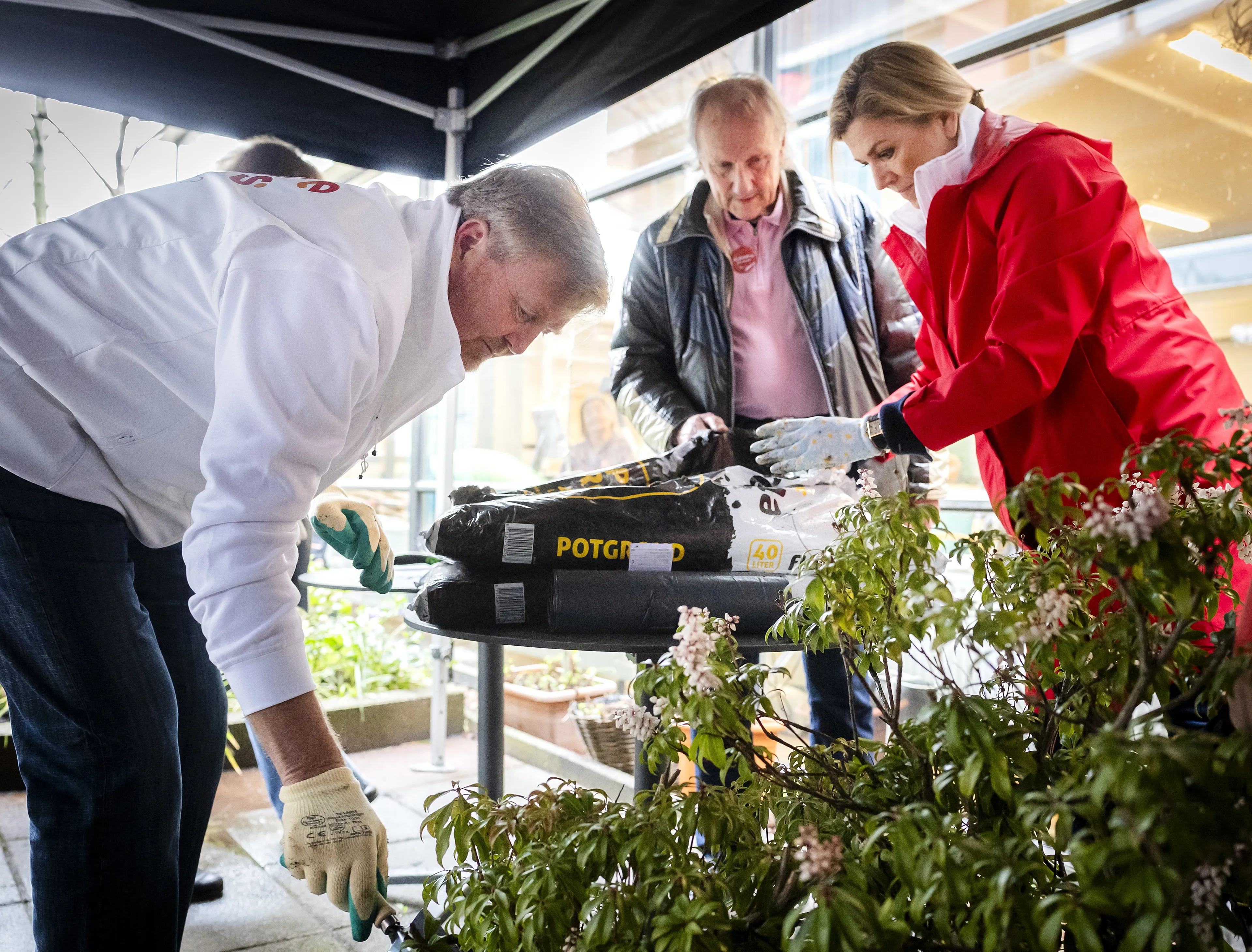 Buiten gaat een felrode parka aan.