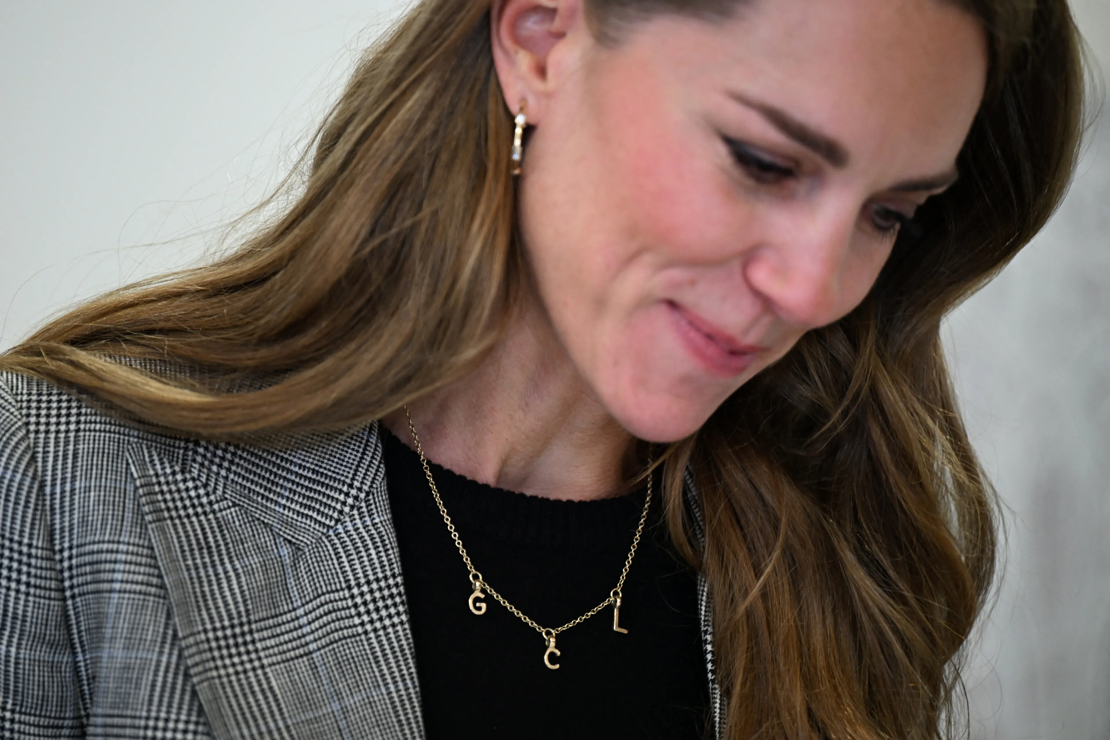 De bedelketting met de letters 'G' 'C' en 'L' erop.