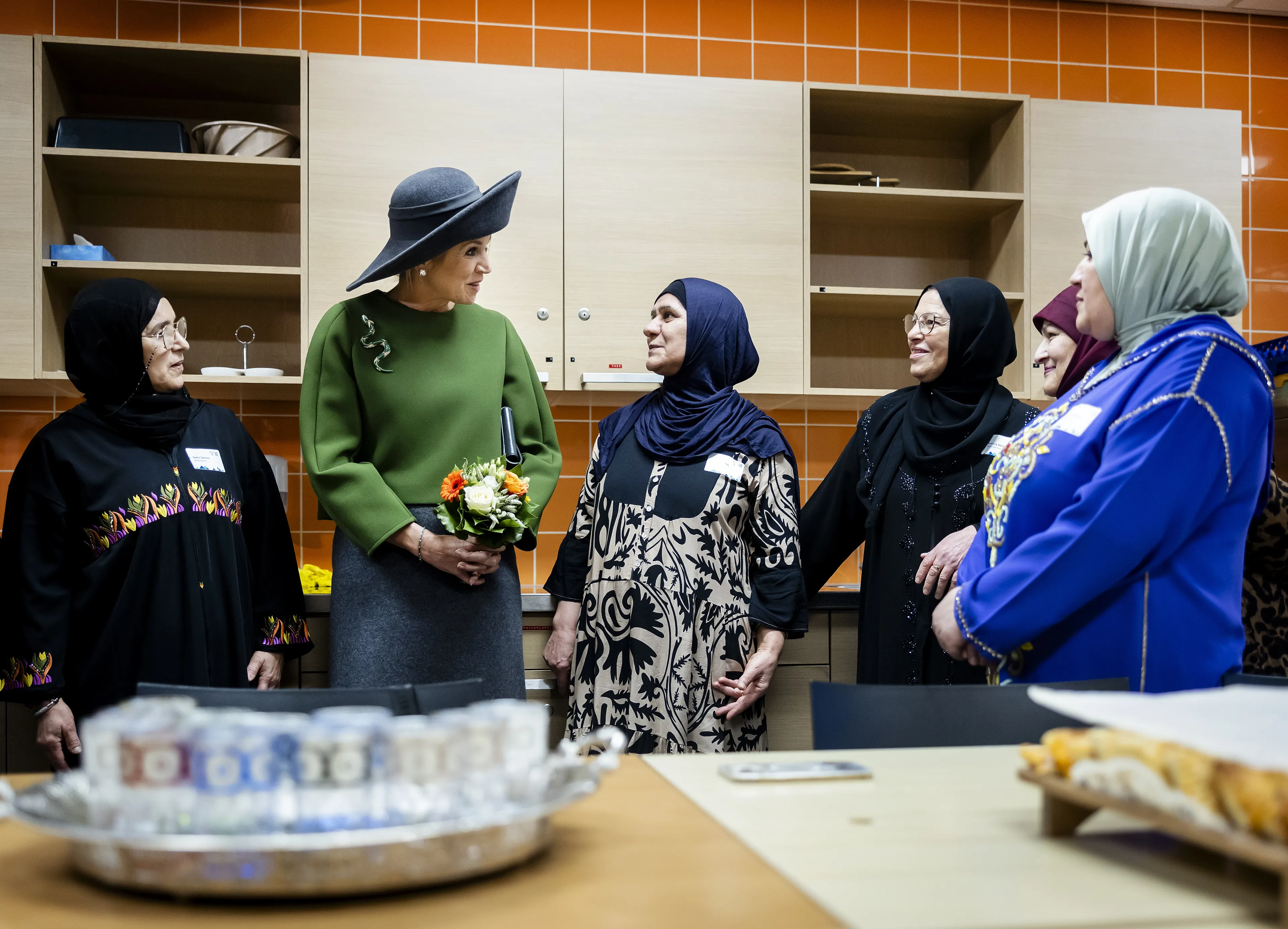 Koningin Máxima draagt een grijze rok en een groene top tijdens een bezoek aan Purmerend.