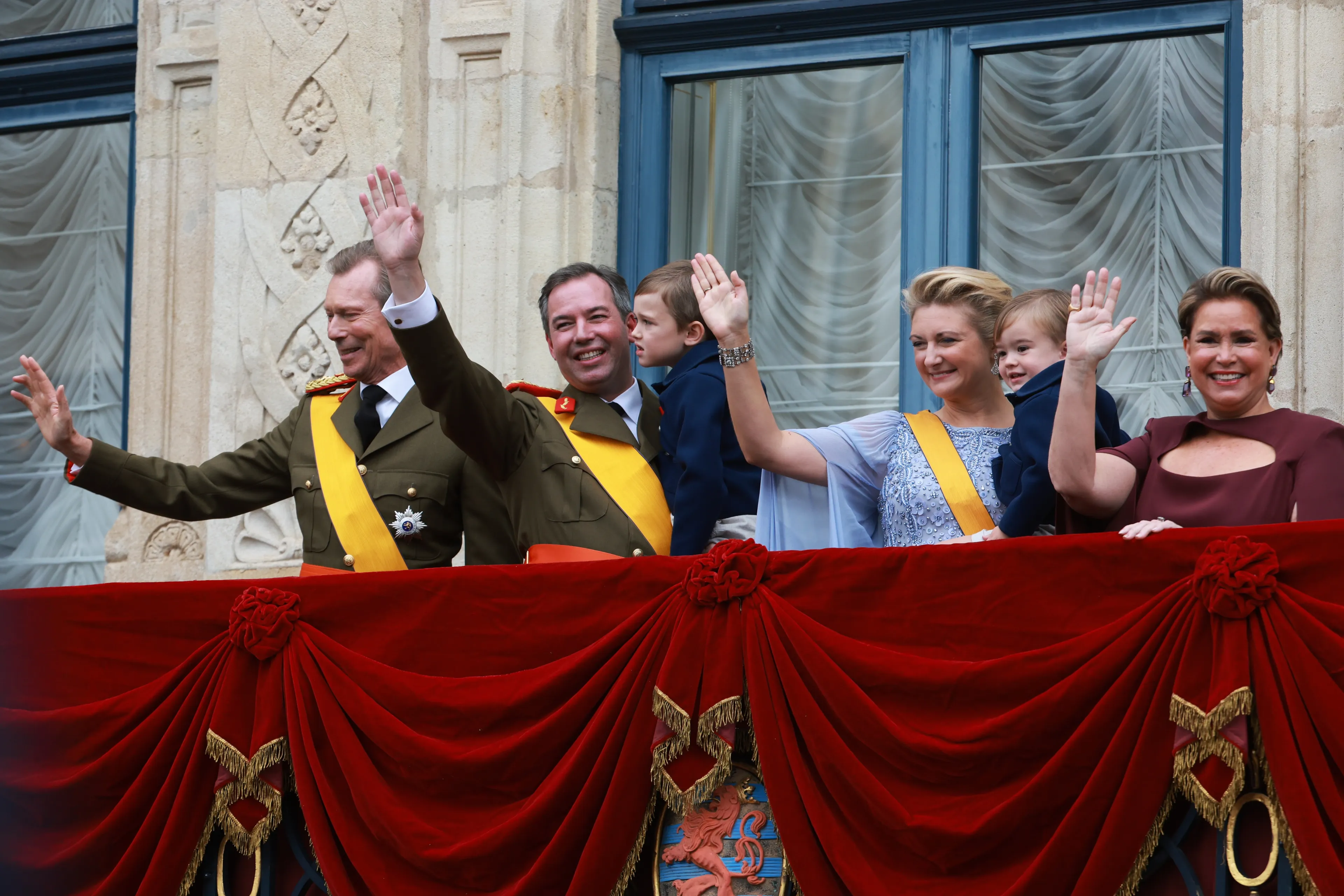 Henri en Maria Teresa bij de troonswisseling zwaaiend op het balkon naast Guillaume en Stéphanie (2025).