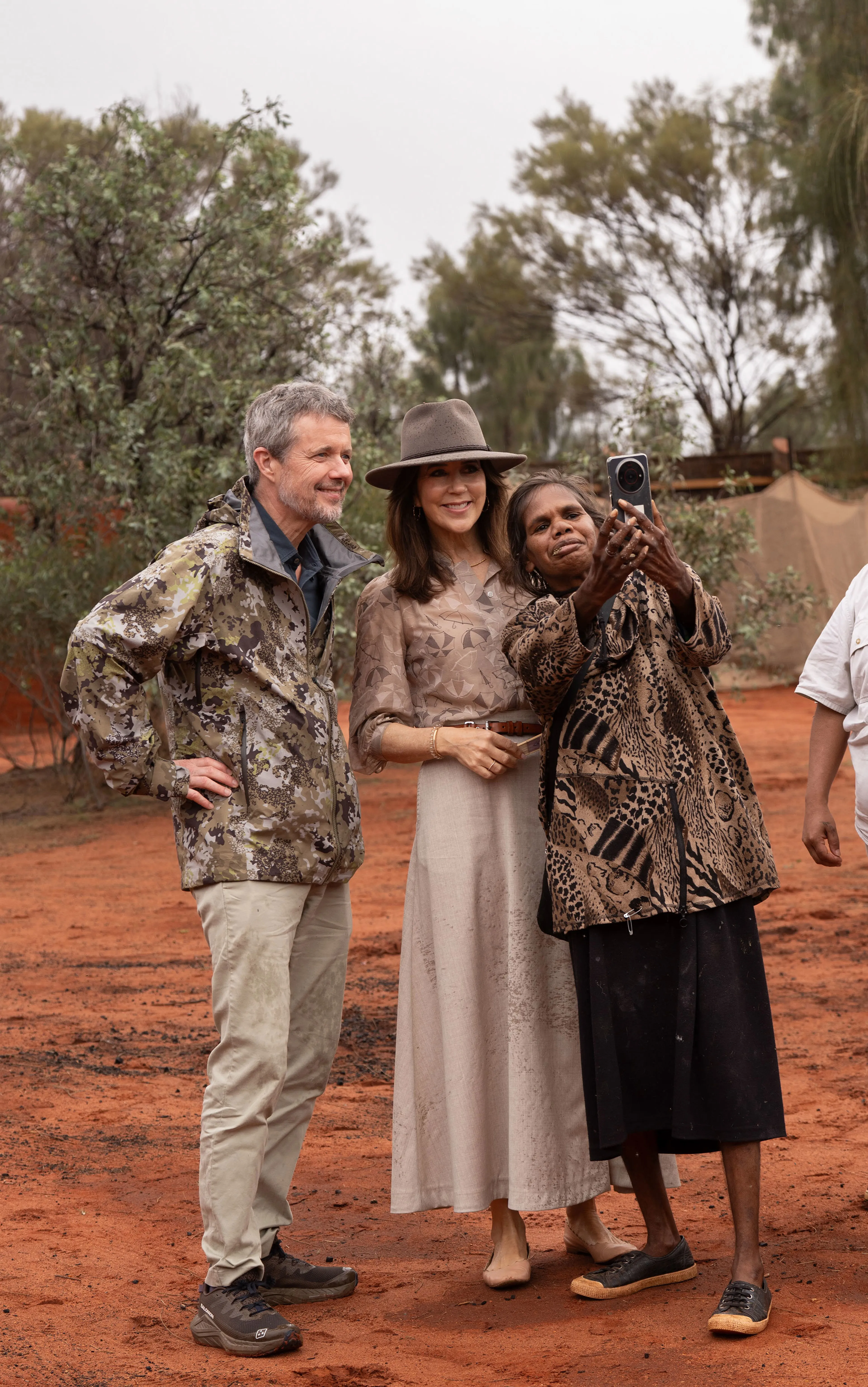 Het koningspaar maakt een selfie met een inwoner.