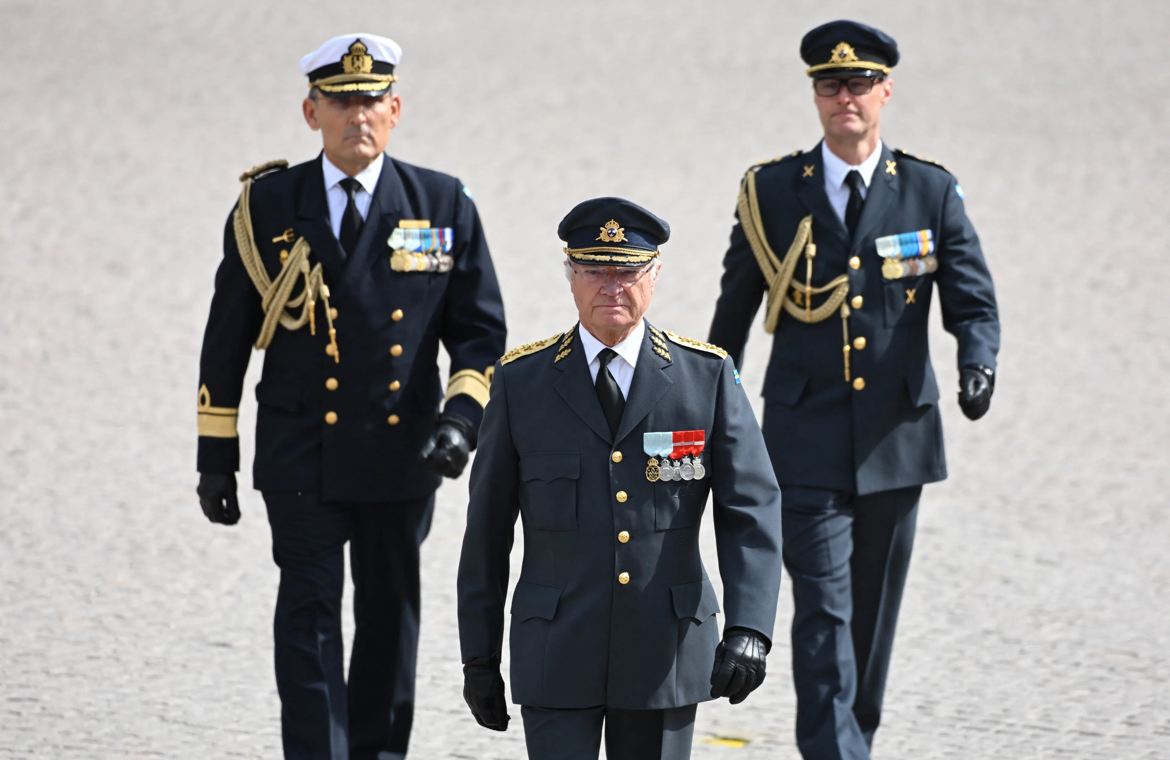 Koning Carl Gustaf bekijkt de militaire parade van dichtbij.