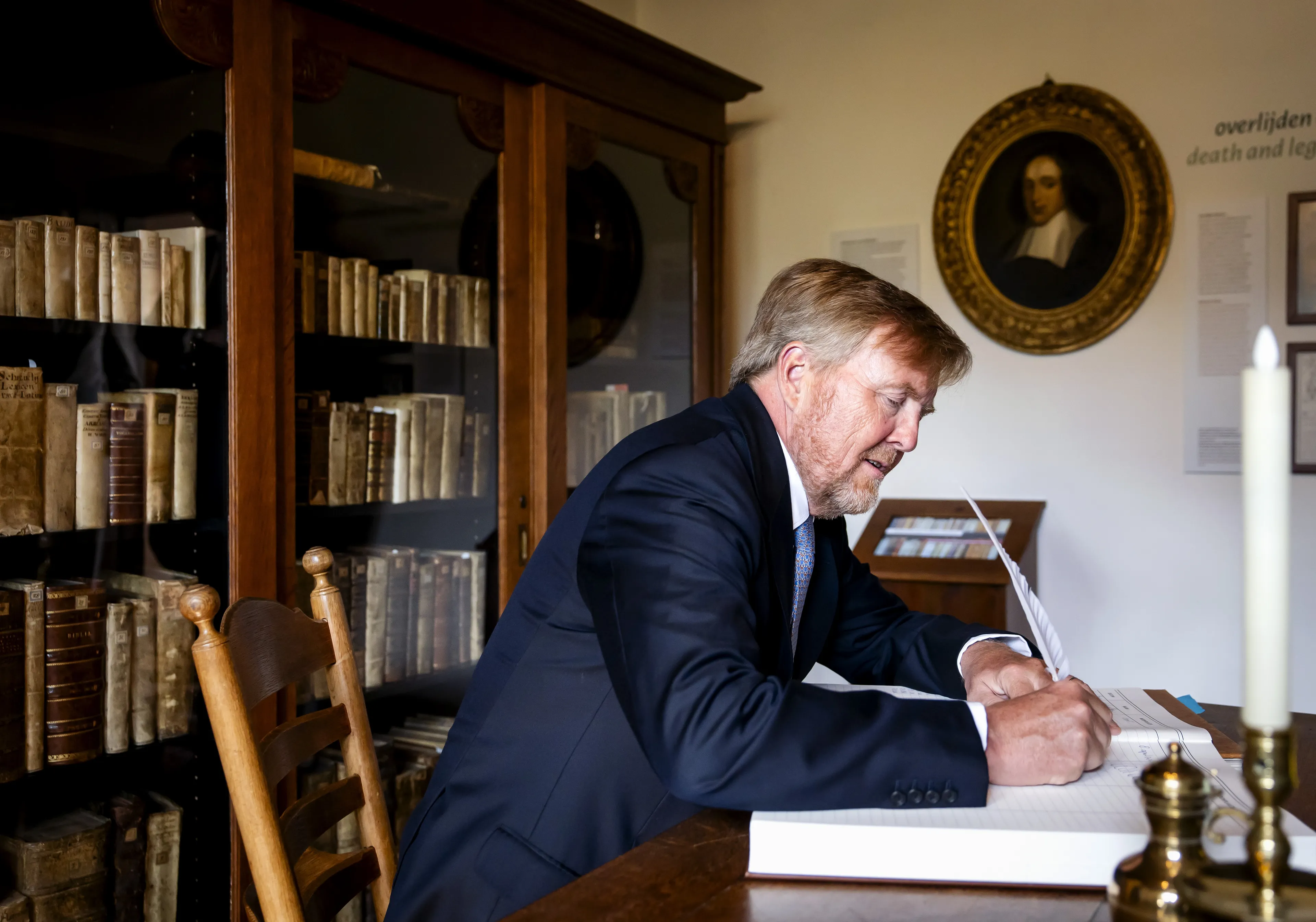 De koning zet zijn handtekening in het gastenboek.