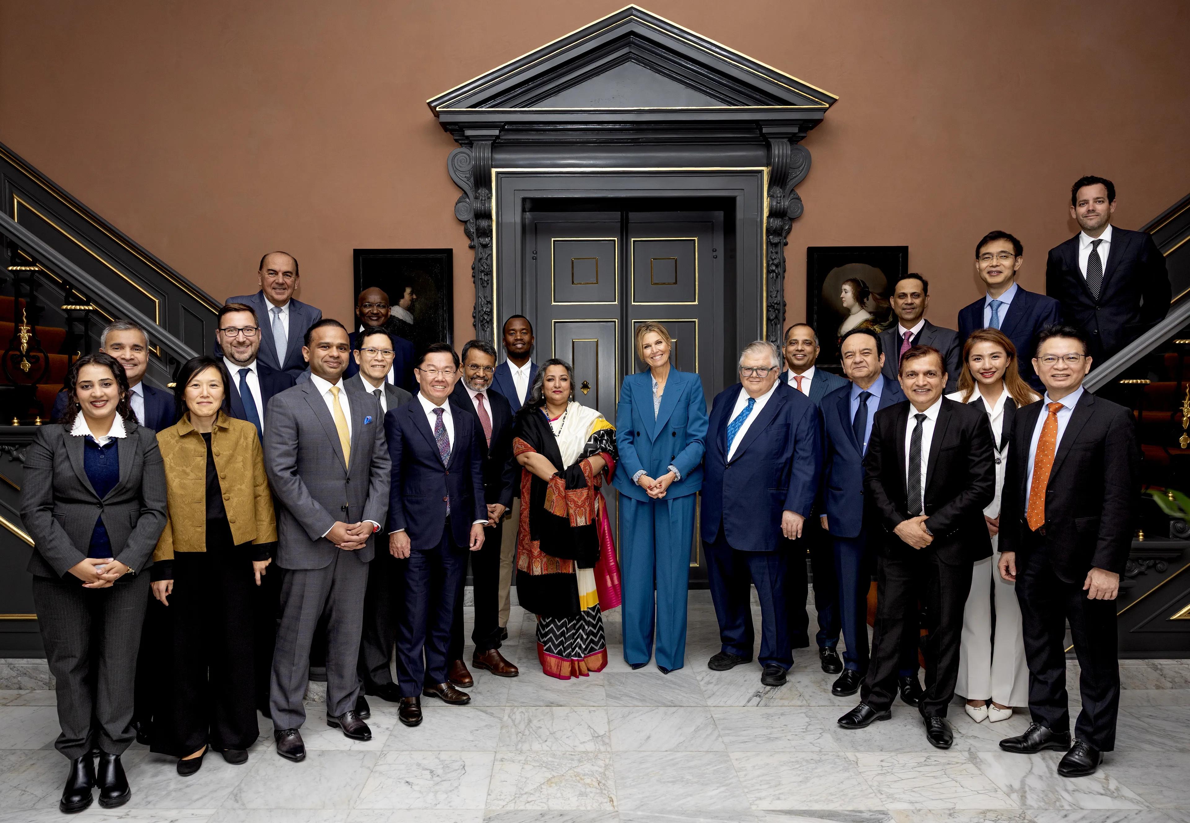 Koningin Máxima met de internationale adviesraad in de vestibule (2025).