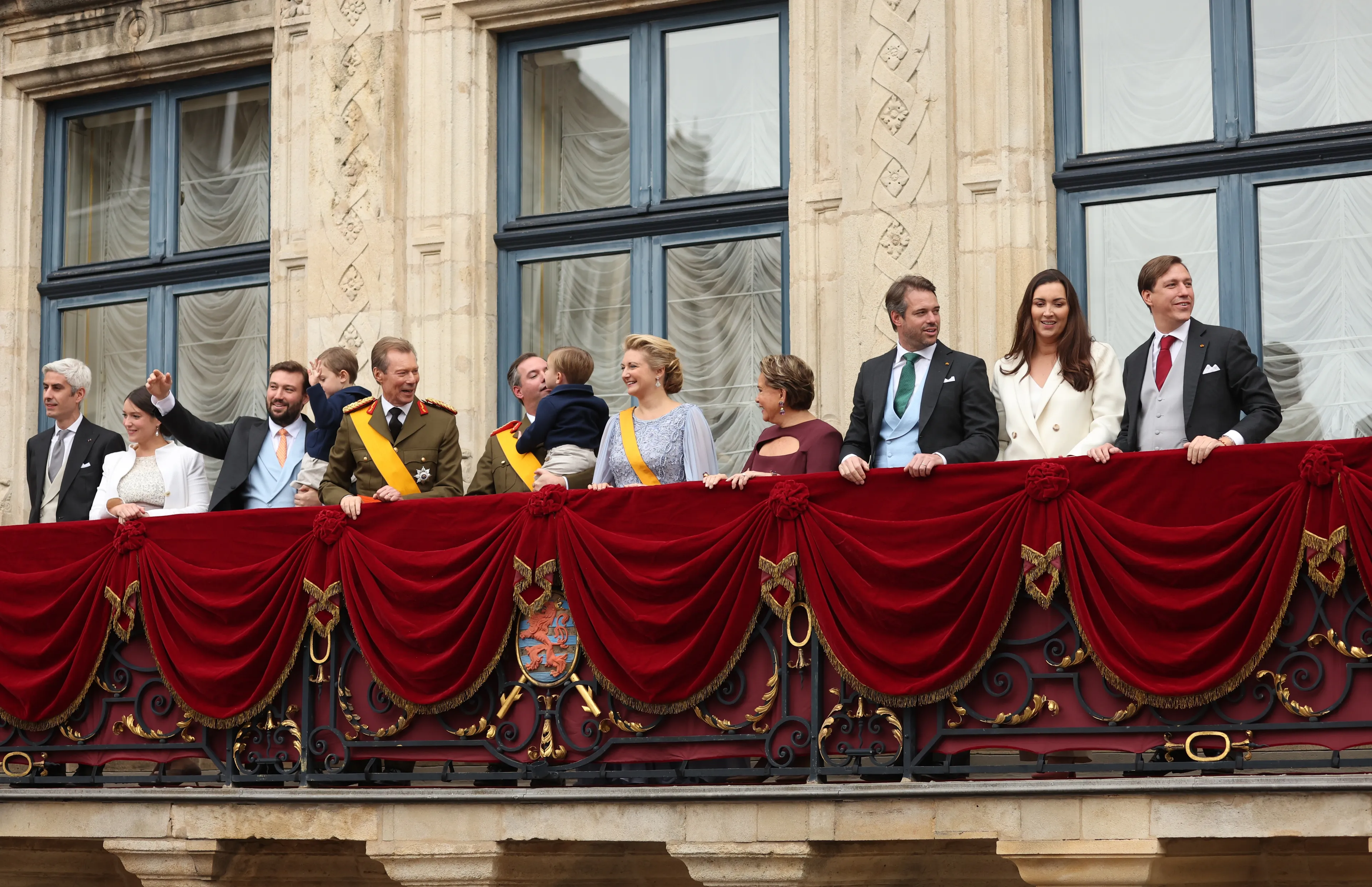 Claire tussen de koninklijke familie op het balkon.