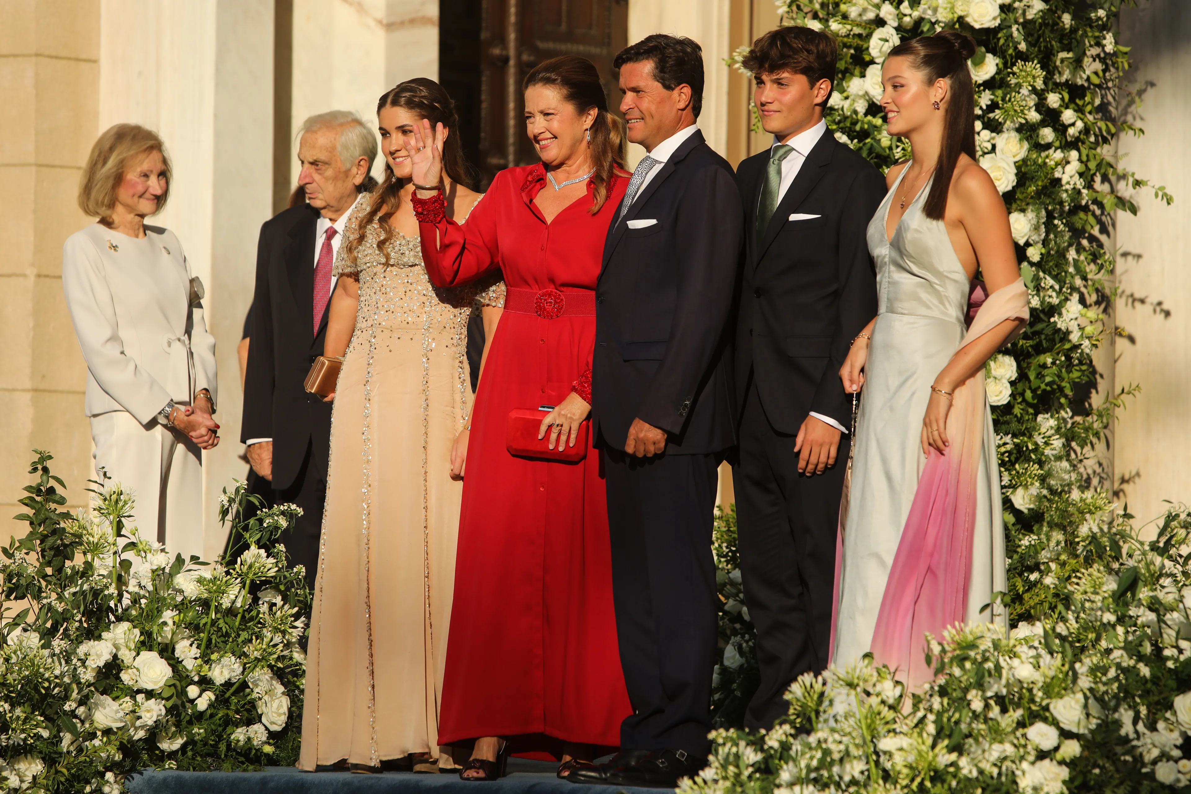 Prinses Alexia, in het midden met de rode jurk, op de bruiloft van prinses Theodora van Griekenland en Denemarken.
