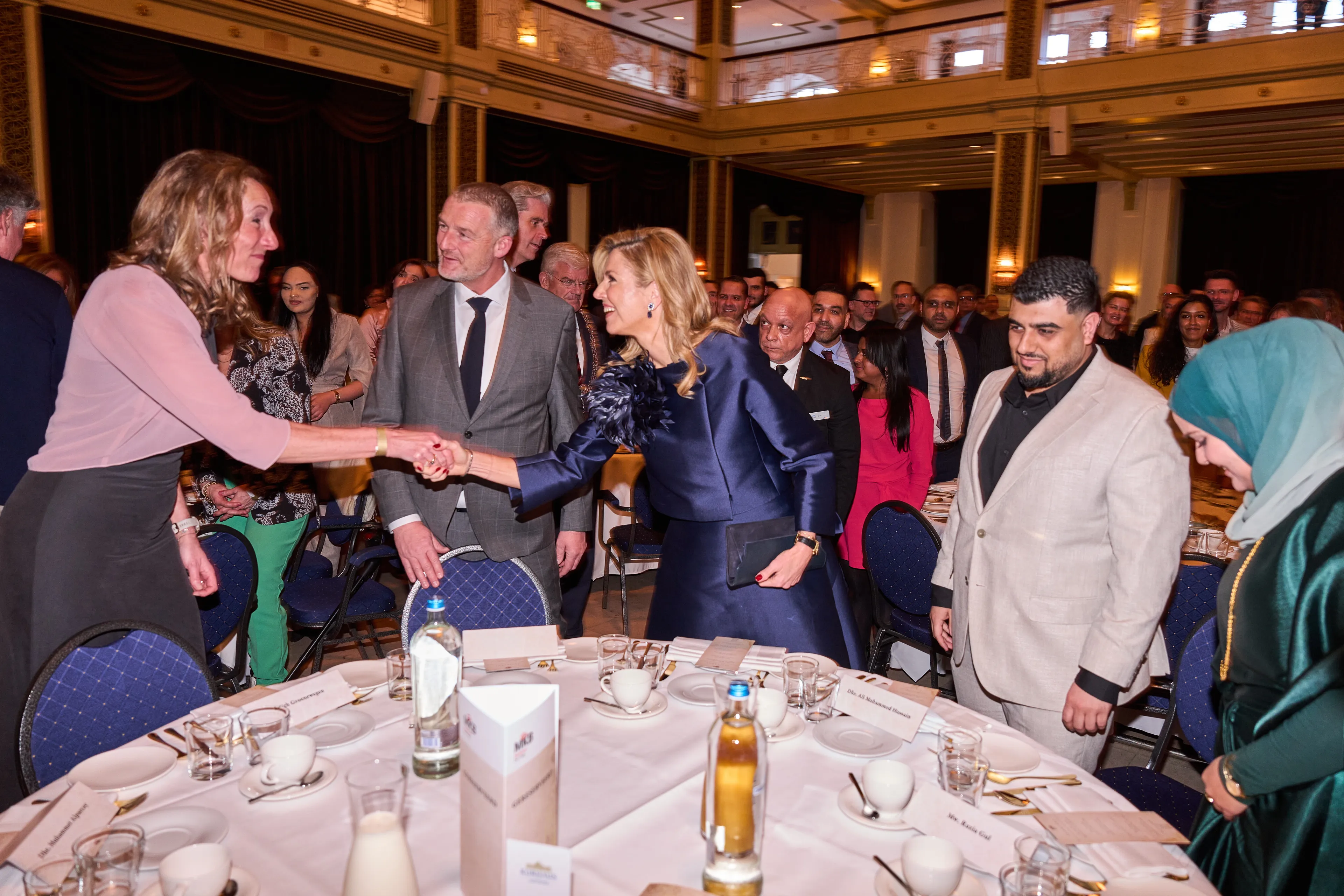 Koningin Máxima ontmoet haar tafelgasten in het Grand Hotel Kurhaus.