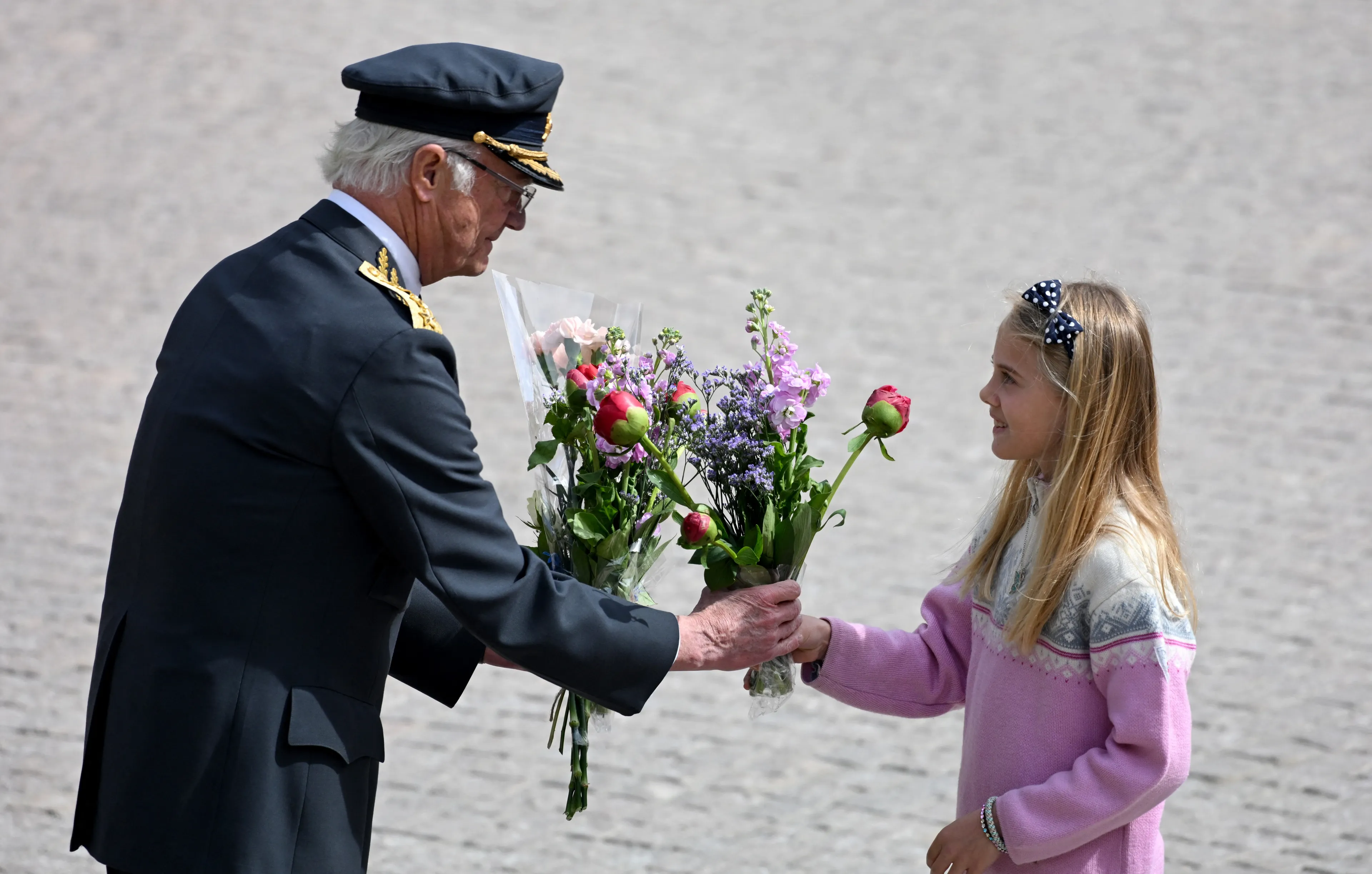 Koning Carl Gustaf neemt een bloemetje in ontvangst.