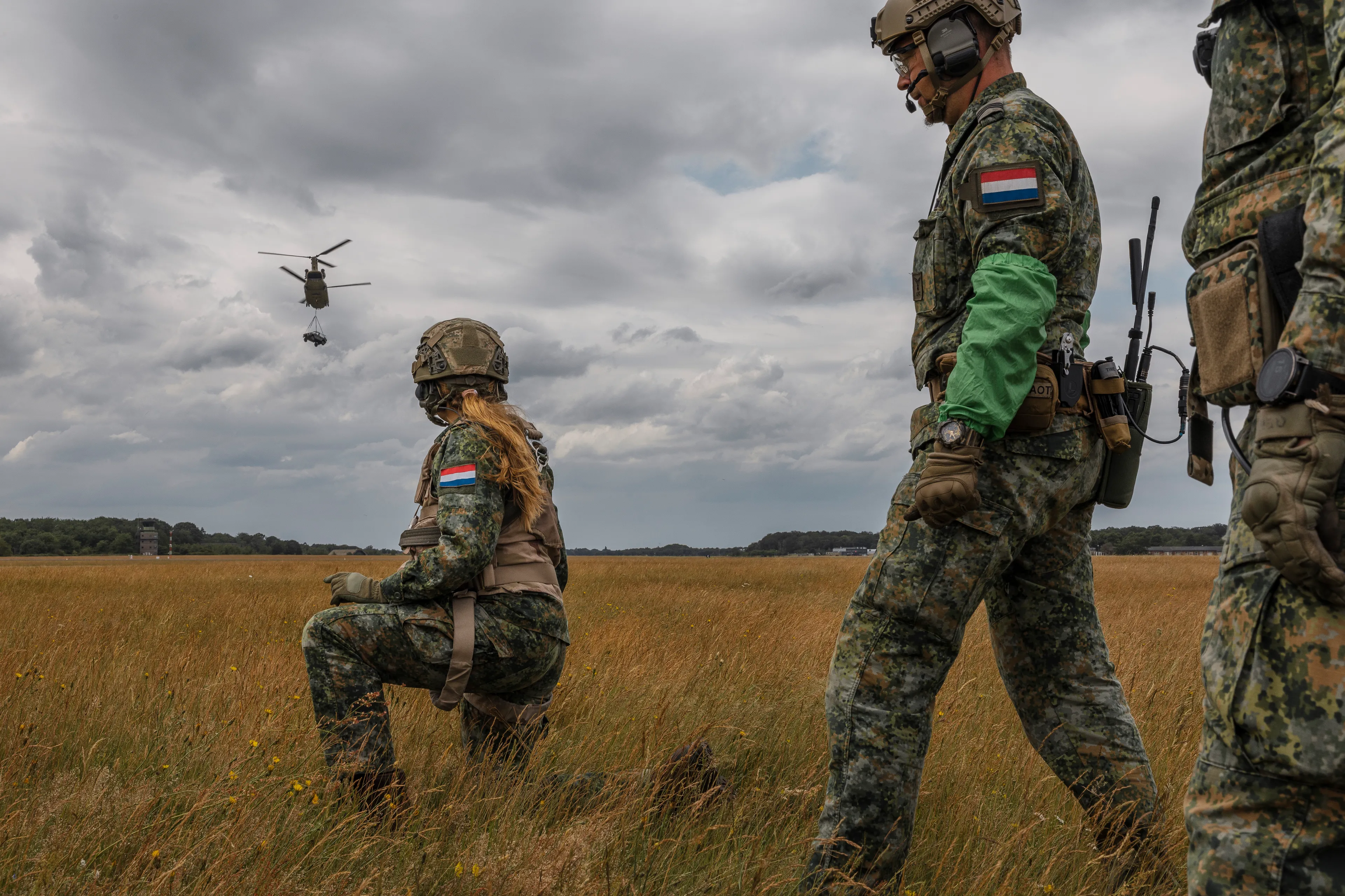 Prinses Amalia werkt samen met reservisten om een lading vast te maken onder de helikopter.