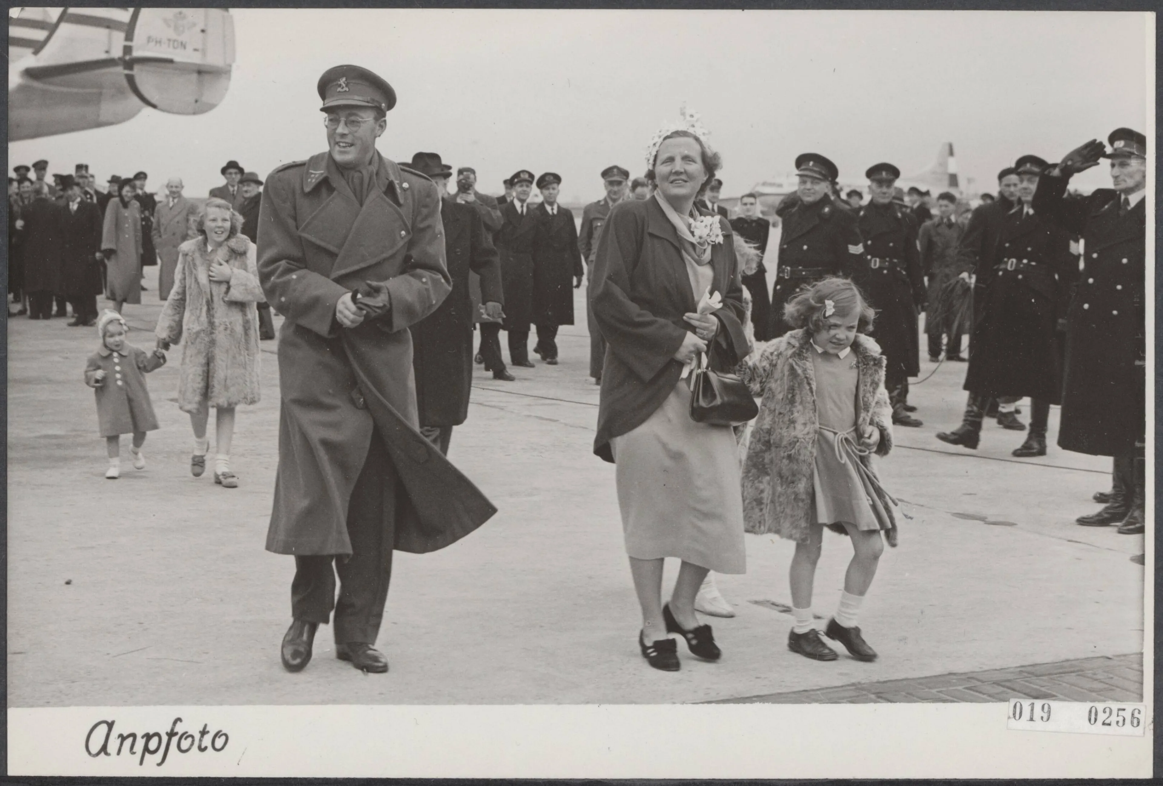 Prins Bernhard met koningin Juliana en prinses Margriet op weg naar de hofauto die ze naar Paleis Soestdijk zal brengen.
