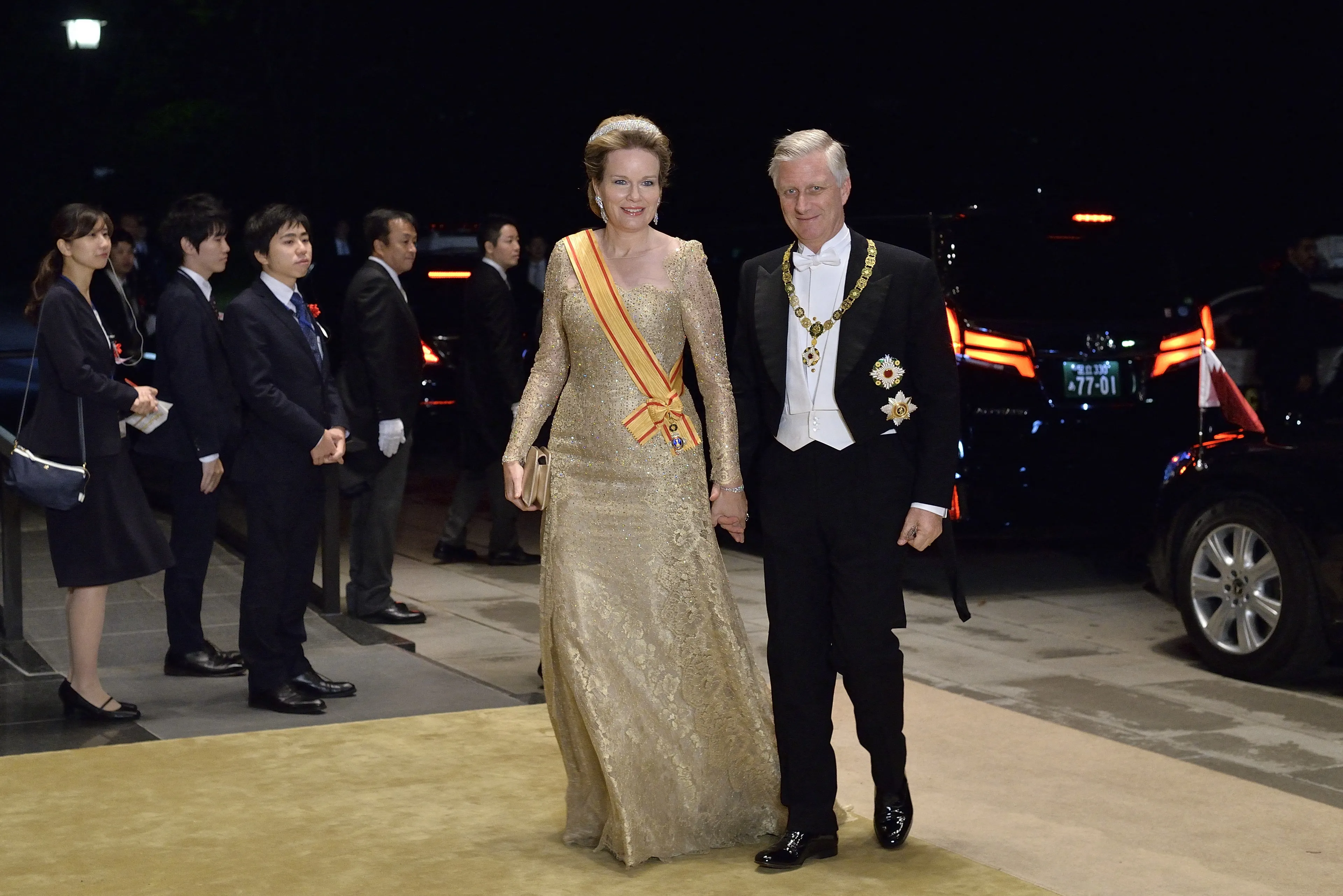 Koningin Mathilde is van top tot teen in het goud gehuld.