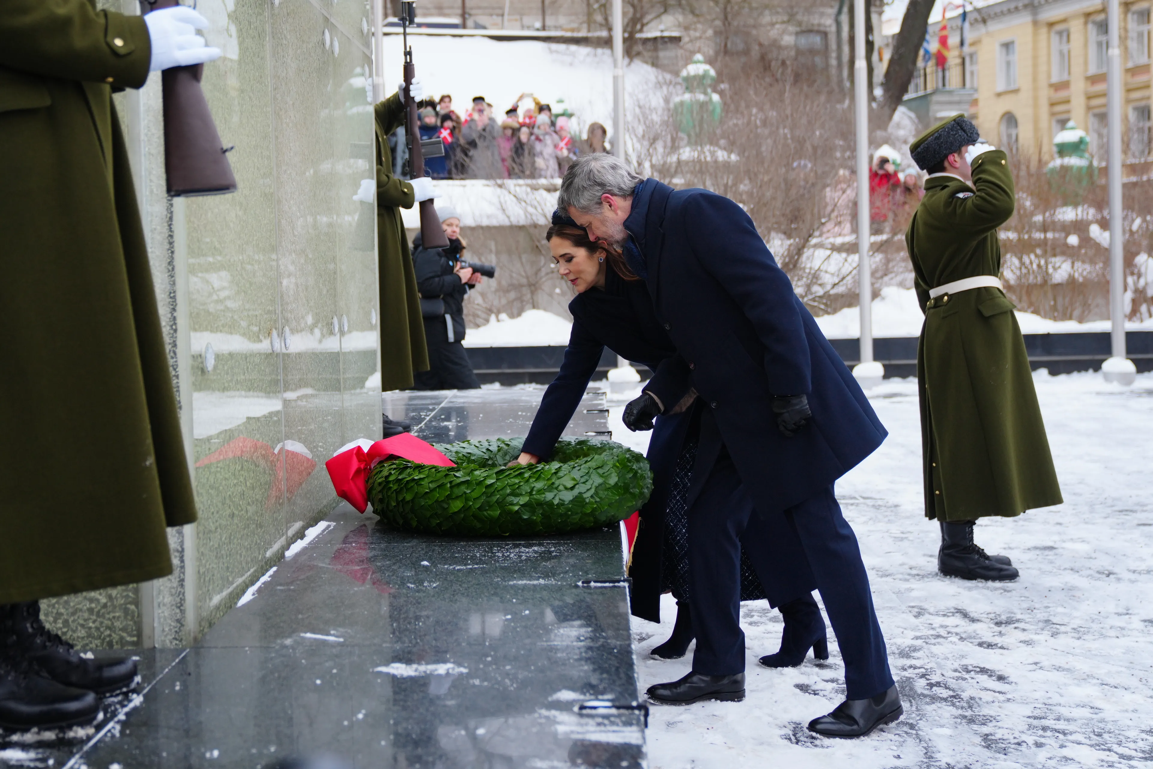 Het paar legt een krans bij het monument.