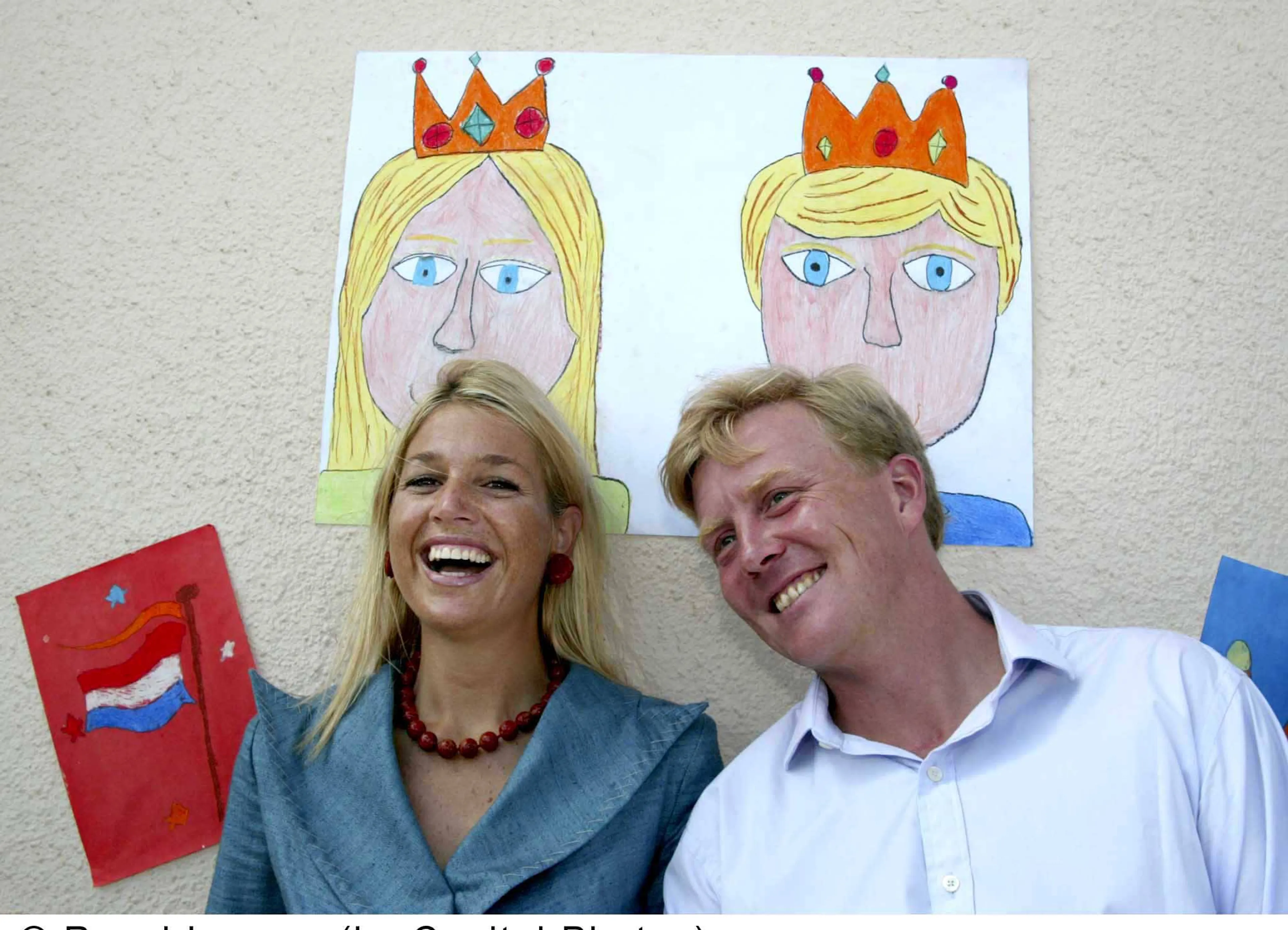 Prins Willem-Alexander en prinses Máxima poseren bij een tekening van hen.