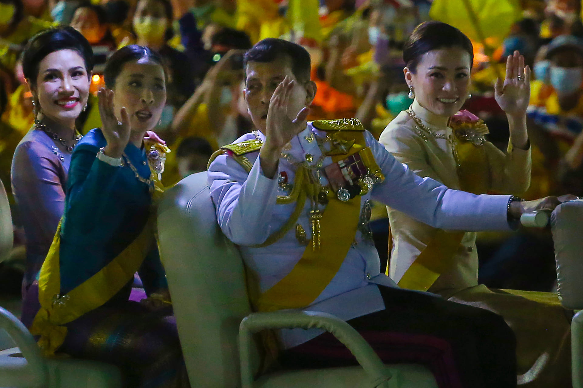 Koning Vajiralongkorn praat met zijn dochter, prinses Bajrakitiyabha Mahidol. Helemaal links zit