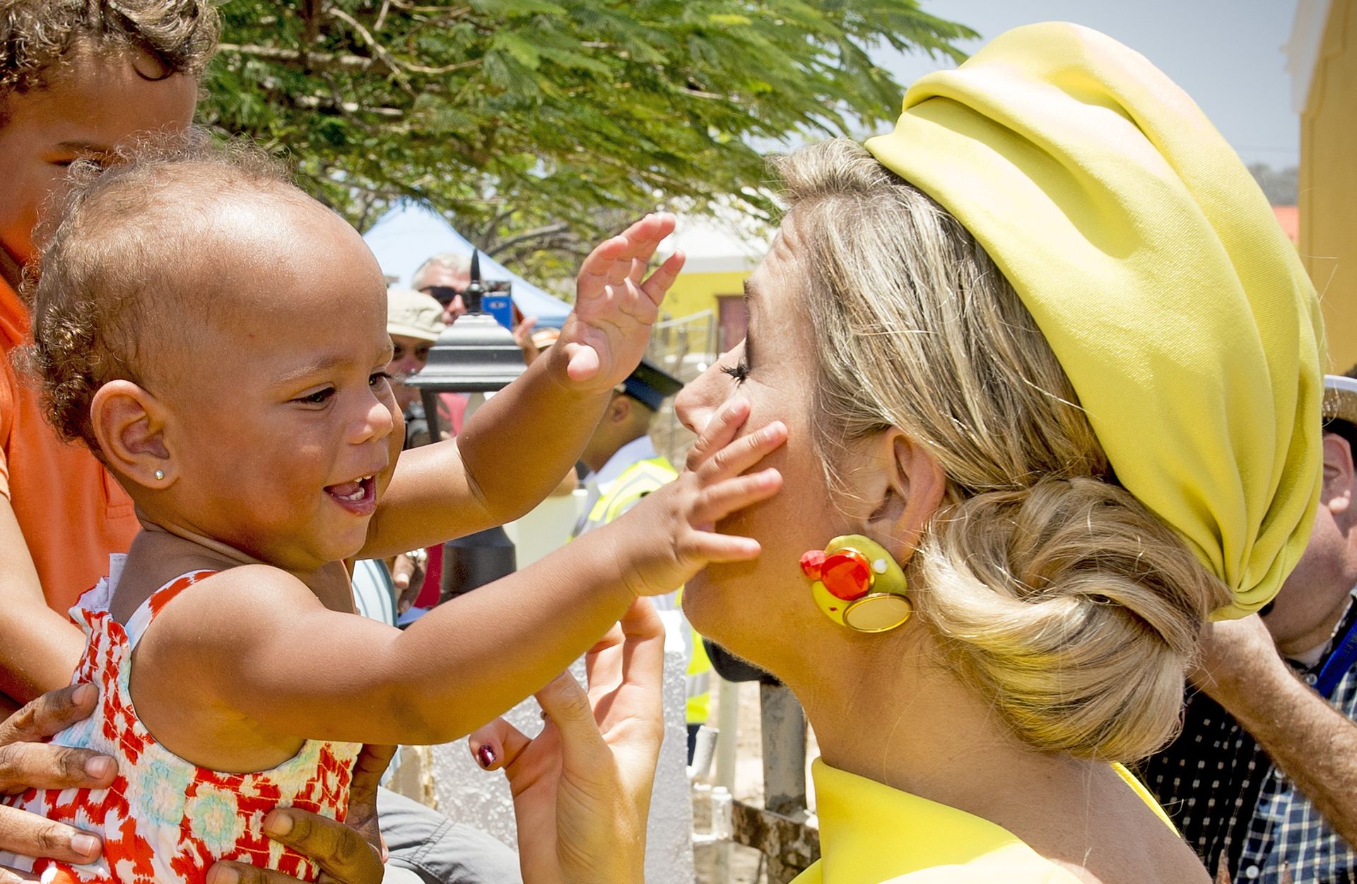 2015 - Koningin Máxima wordt begroet en geknuffeld door een baby tijdens haar bezoek aan Bonaire.