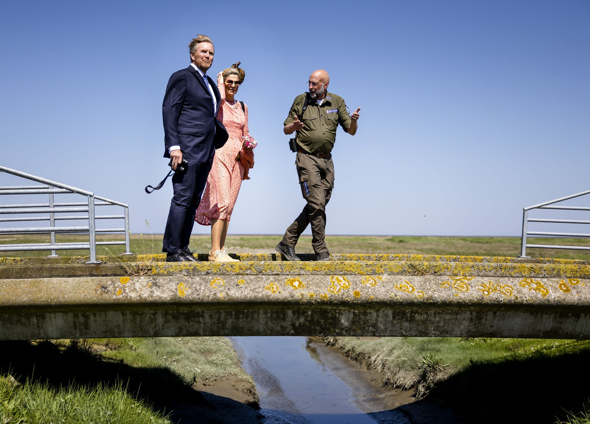 Koning Willem-Alexander en koningin Maxima tijdens een kwelderwandeling met een boswachter van Natuurmonumenten.