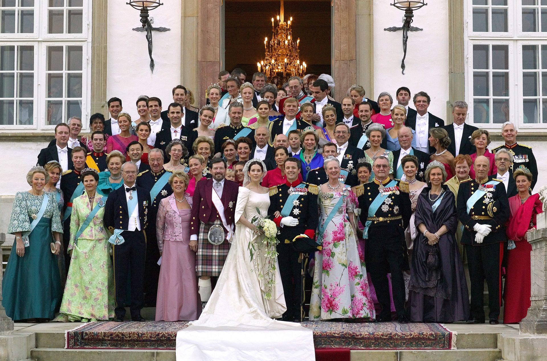 Kroonprins Frederik en kroonprinses Mary poseren met familie en gasten voor de ingang van paleis Fredensborg in 2004.