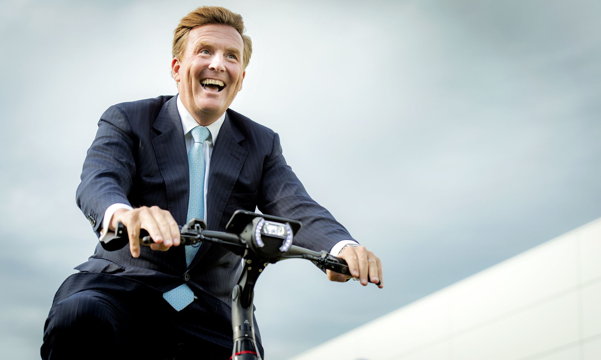 De koning fietst voor deze gelegenheid op een e-bike, de 'fiets van de toekomst'.