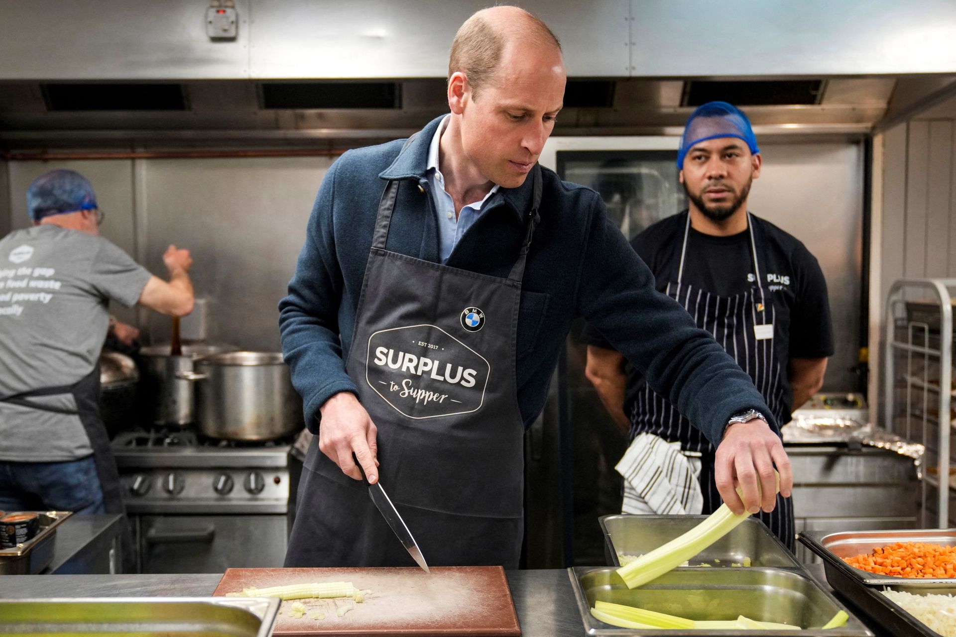 Prins William snijdt bleekselderij terwijl hij helpt bij het maken van een bolognesesaus tijdens zijn bezoek aan Surplus to Supper.