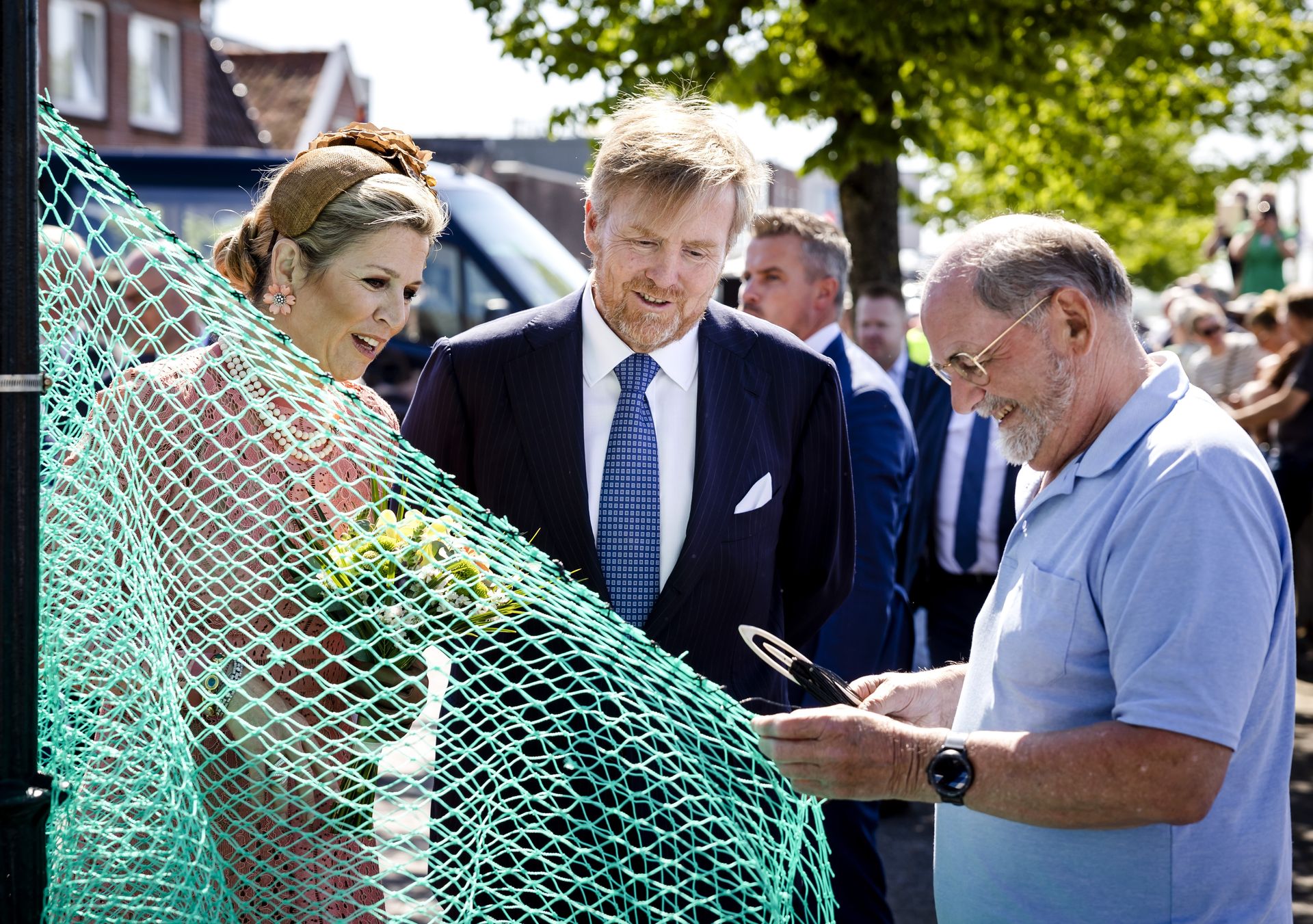 Koning Willem-Alexander en koningin Maxima in gesprek met een nettenboeter tijdens hun bezoek aan Zoutkamp