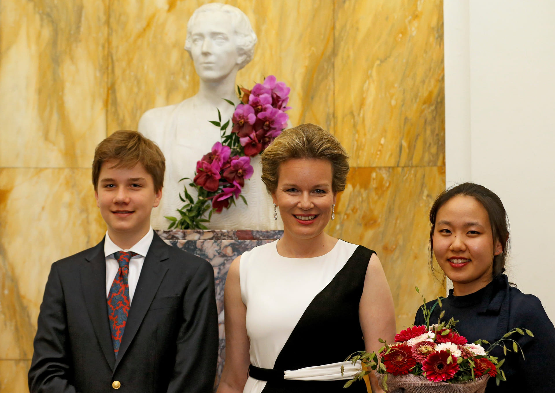 Koningin Mathilde poseert met zoon Gabriël en de winnares van de Koningin Elizabethwedstrijd in