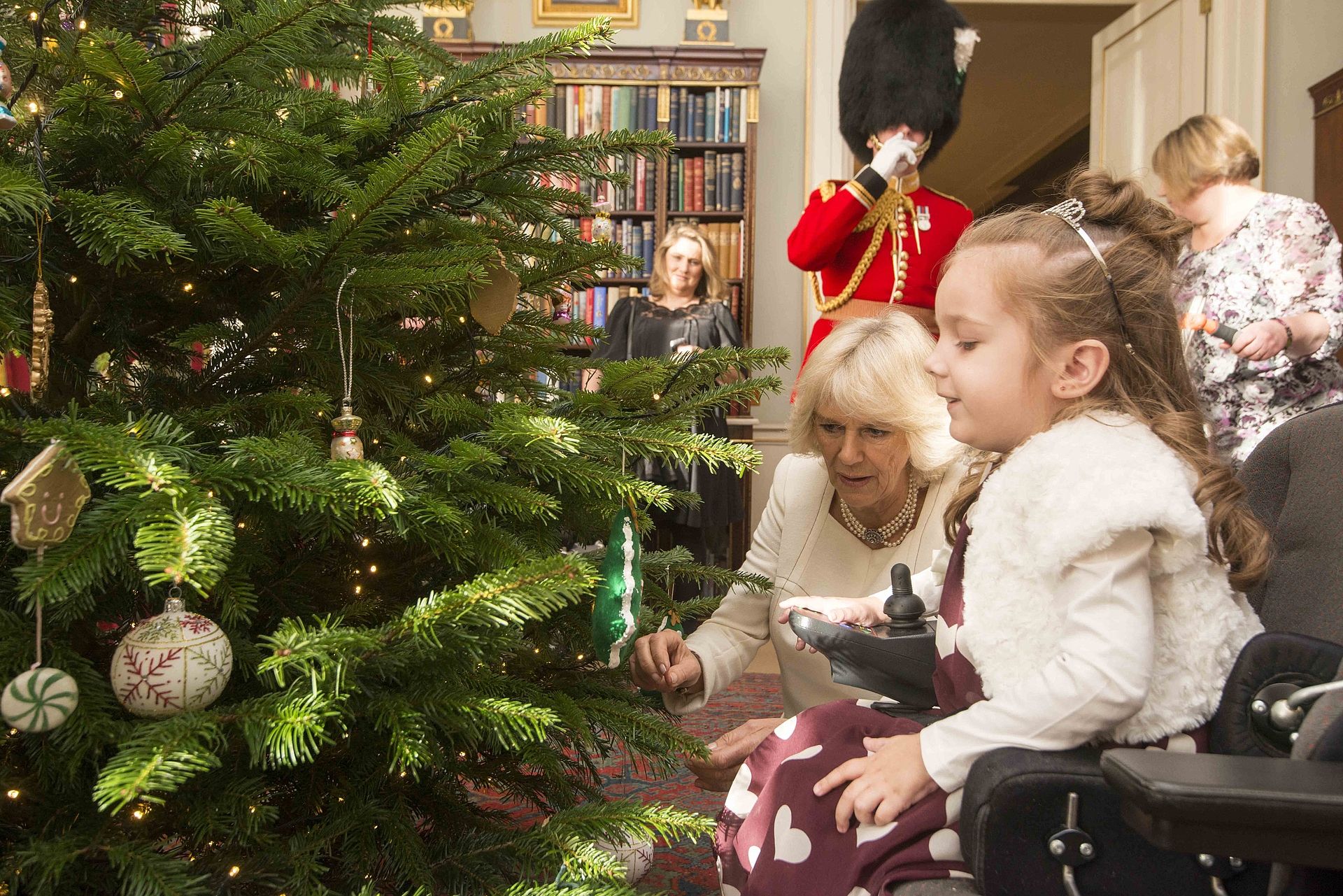 Camilla krijgt hulp bij het versieren van de kerstboom tijdens de receptie van Helen en Douglas