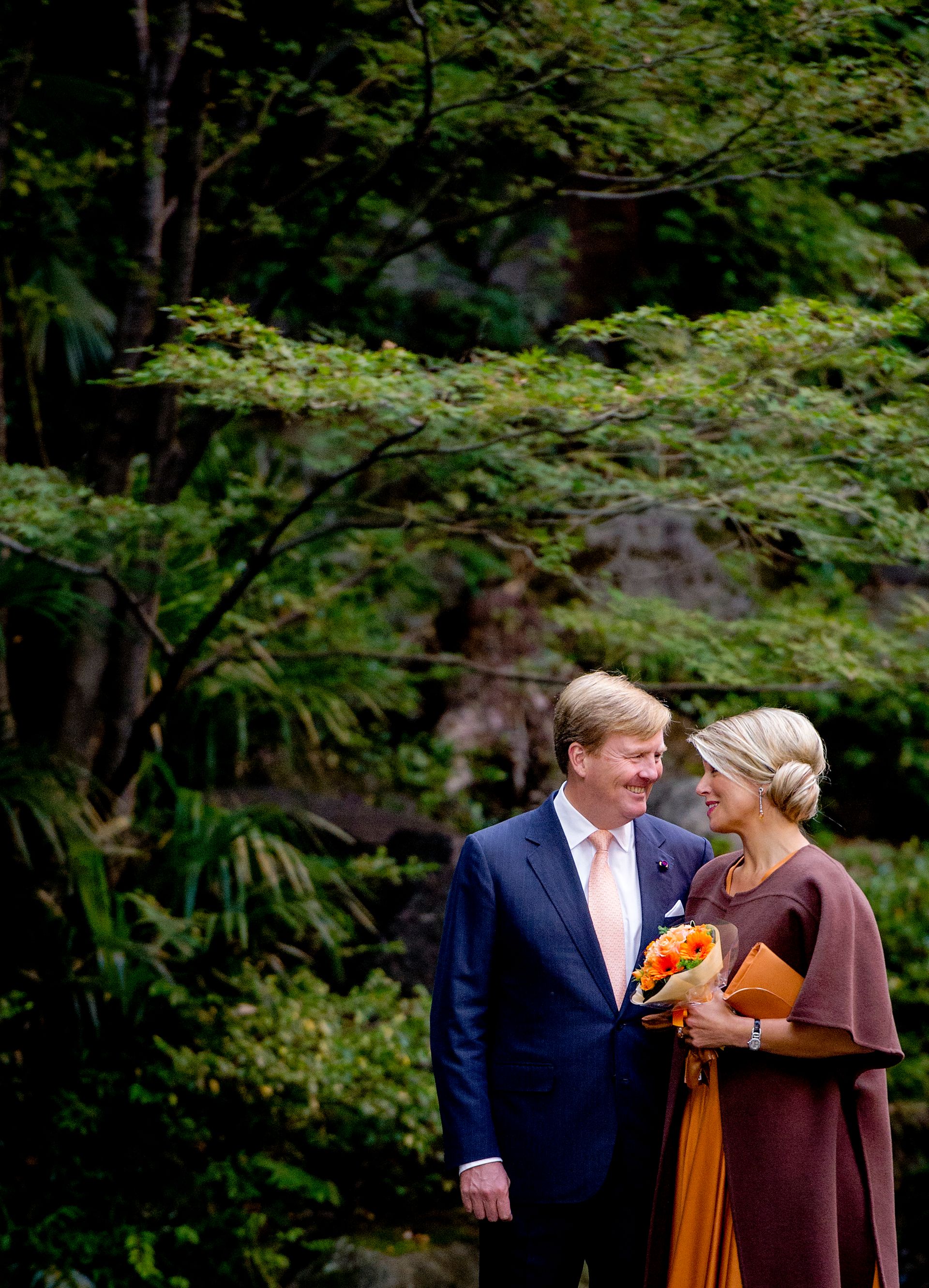 Koning Willem-Alexander en koningin Máxima poseren in de tuin van een boeddhistische tempel op de
