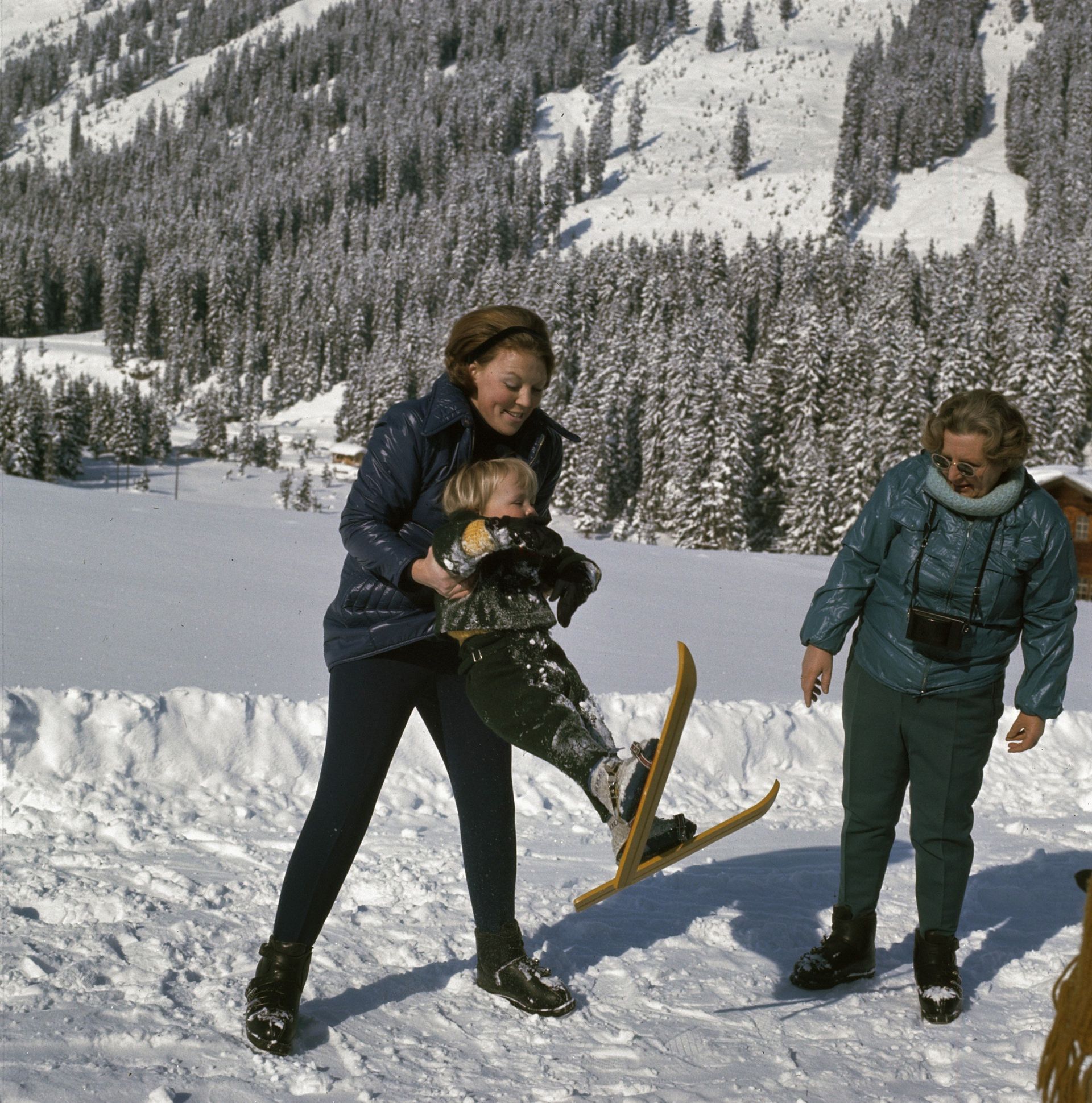 1971: Beatrix geeft haar zoon Friso een lesje skiën. Oma Juliana kijkt toe.