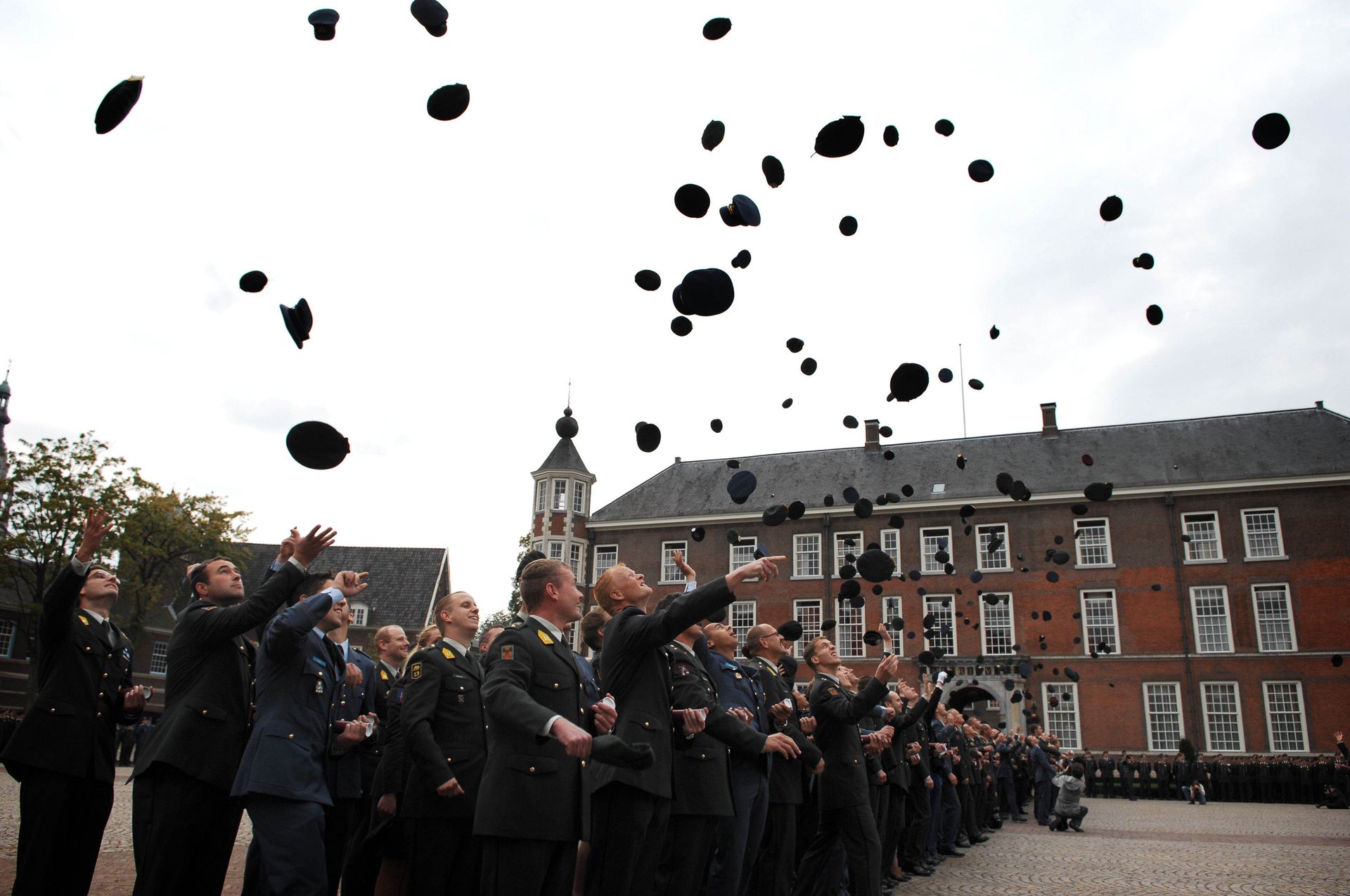 Nieuwe cadetten gooien hun petten in de lucht bij het Kasteel van Breda.