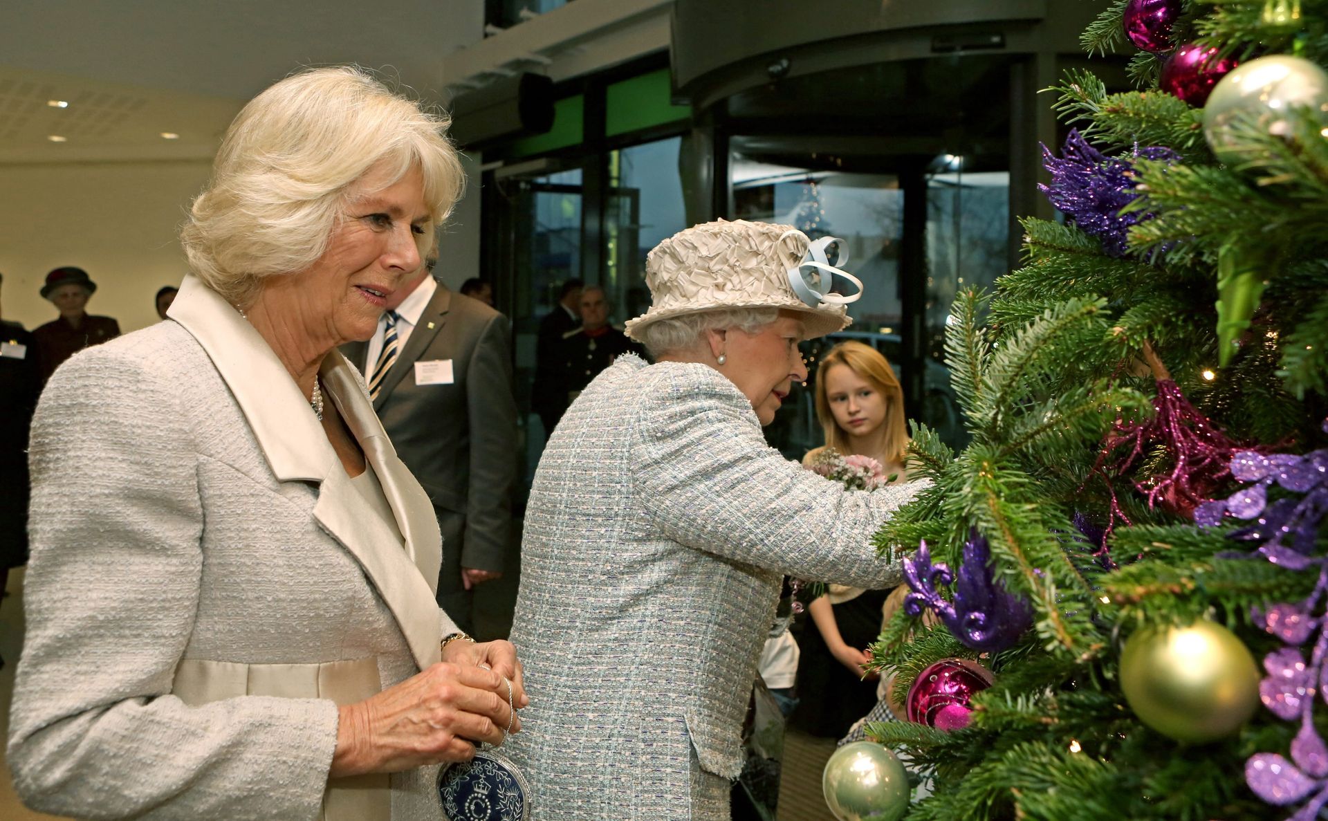 2013: koningin Elizabeth en hertogin Camilla hangen kerstballen in een kerstboom tijdens een bezoek