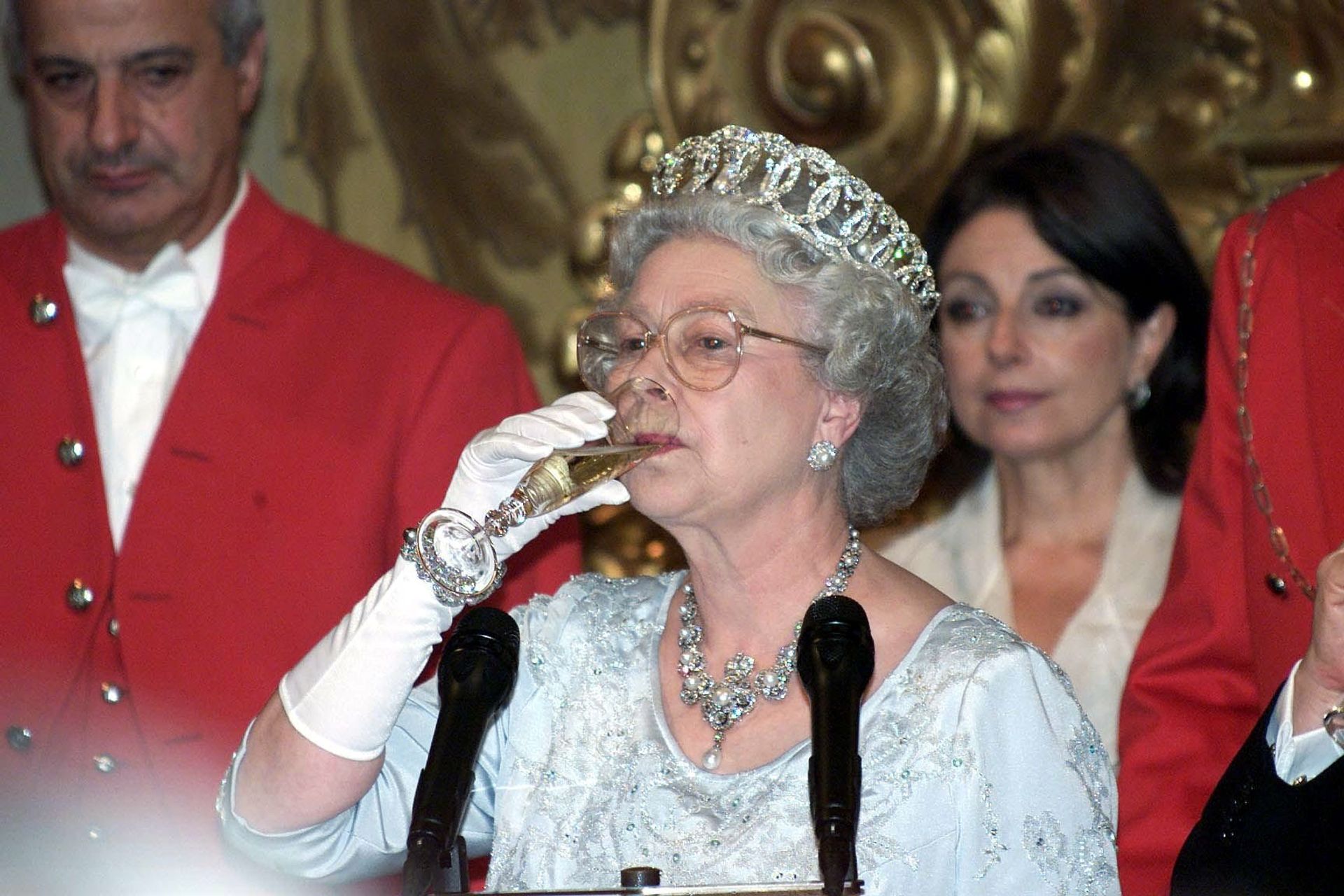 Koningin Elizabeth neemt een slokje van haar champagneglas tijdens haar toespraak bij een staatsbanket in Rome (2000).