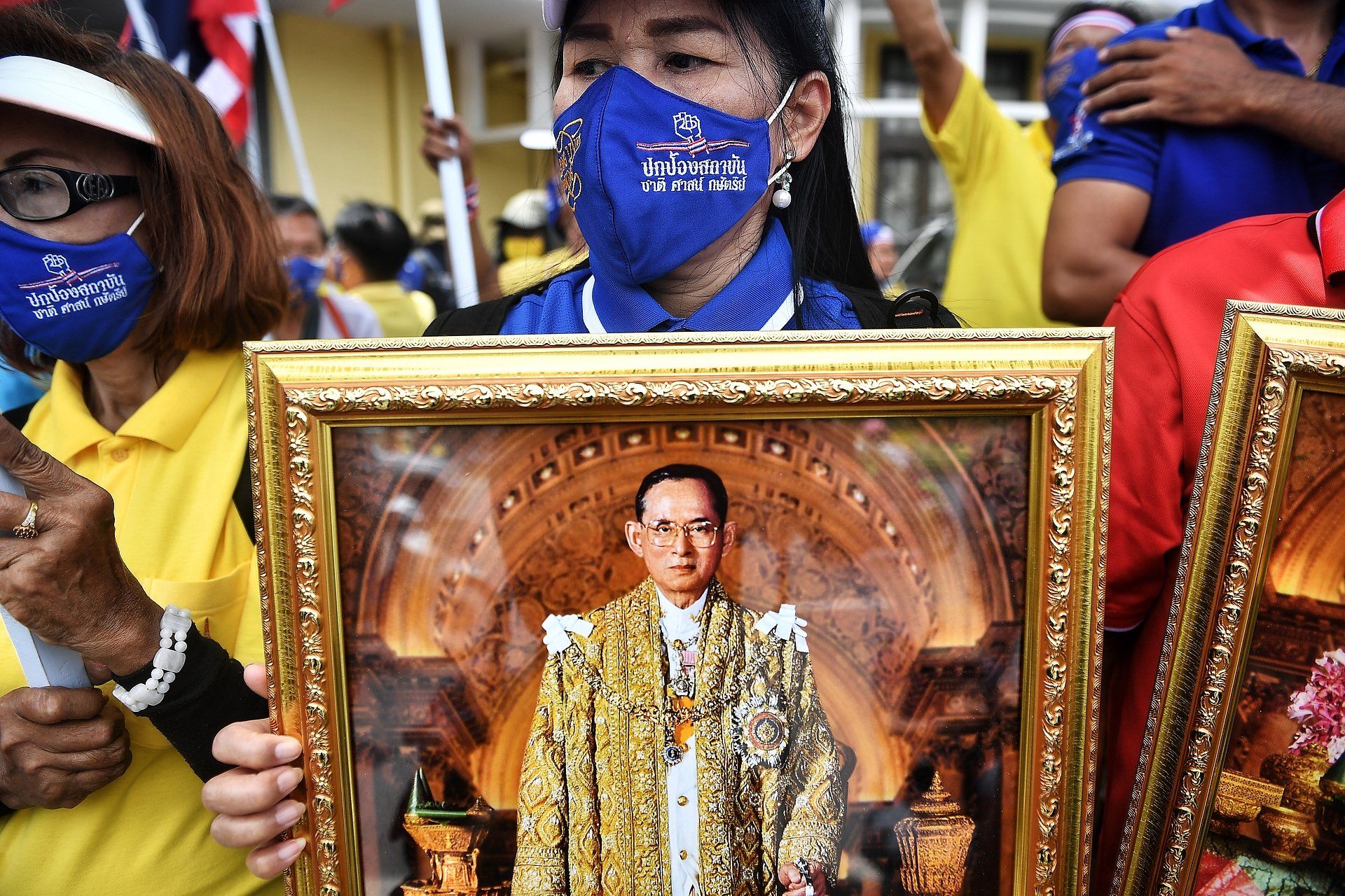 Een pro-koningshuis protesteerder houdt een foto van de overleden koning Bhumibol Adulyadej omhoog.